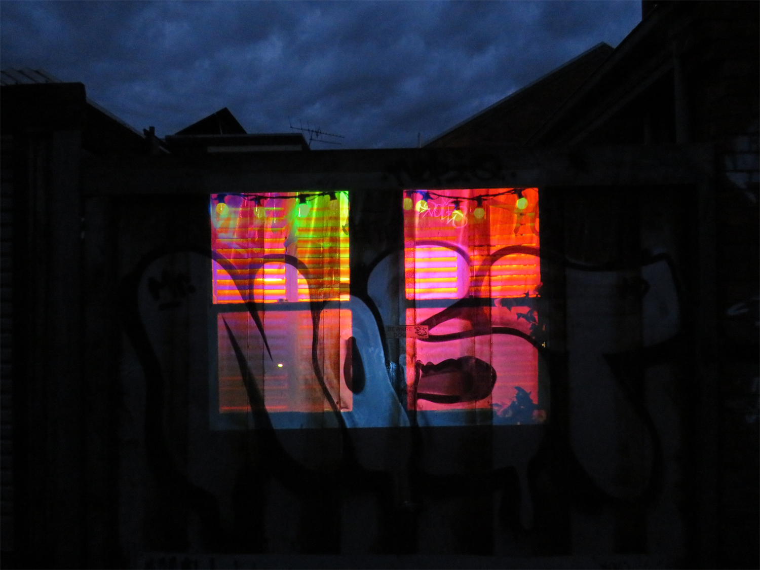 Colourful Window Projected onto Wall with Graffiti at Dusk