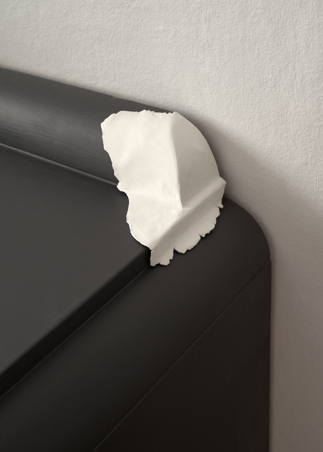 Clay pressed into the detail of curved fireplace mantle 