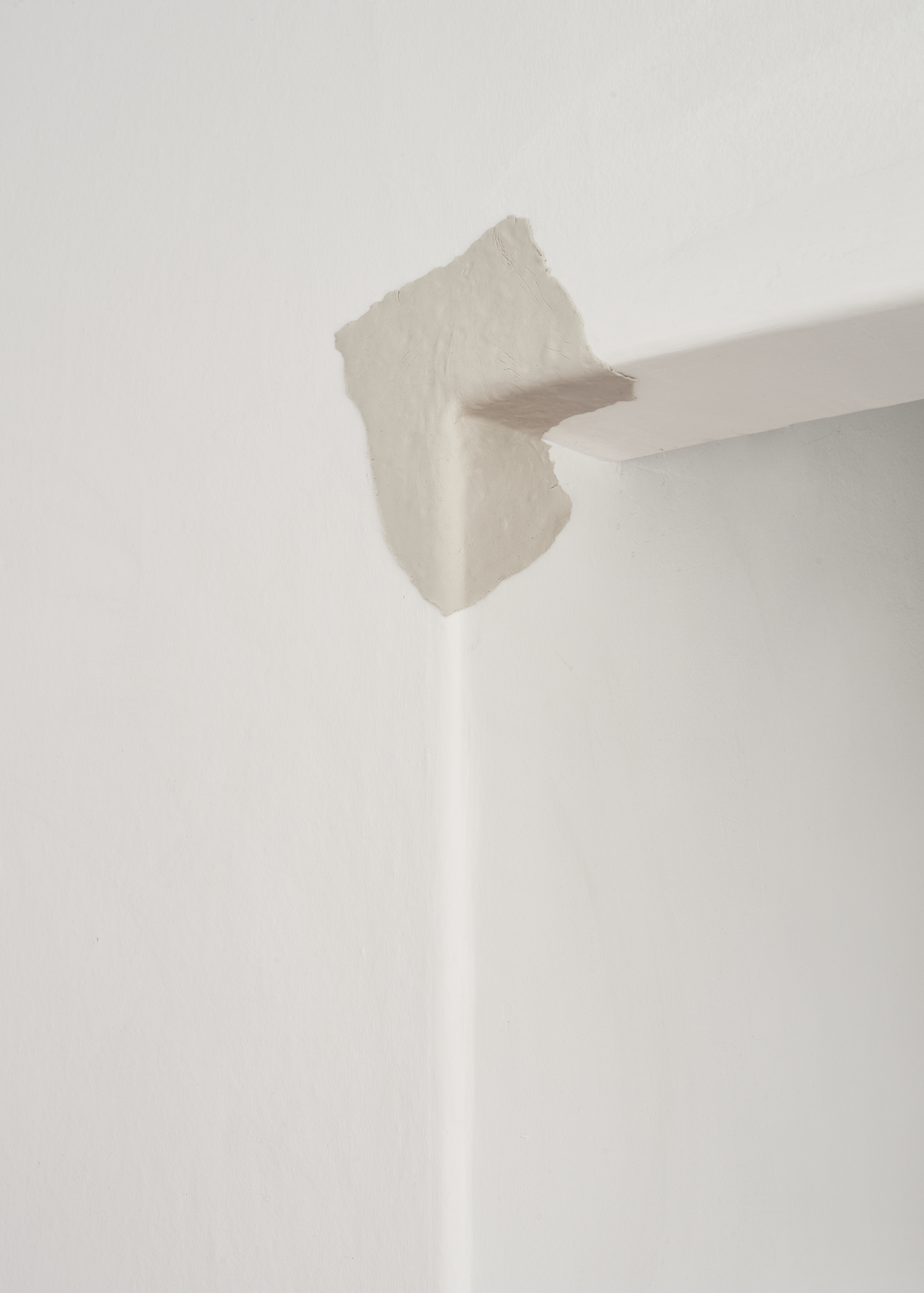 Clay pressed into the corner of white door frame
