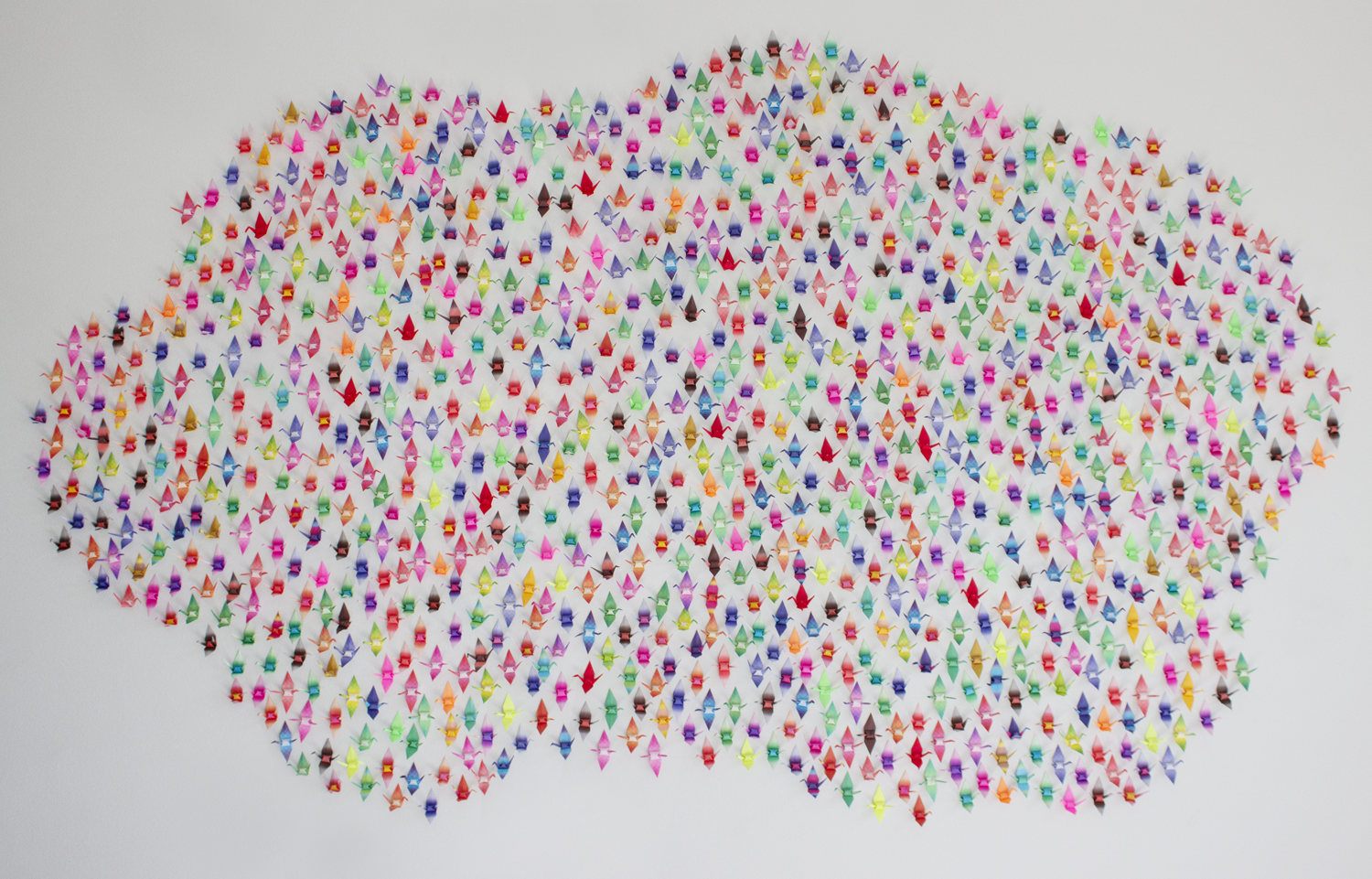 1000 paper cranes arranged in a cloud shape on a wall