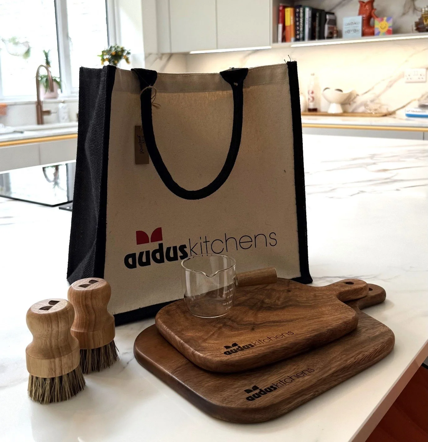 Selection of Audus Kitchens branded goodies on a white kitchen counter.