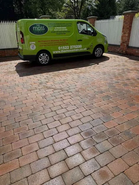 green van on a freshly cleaned driveway.
