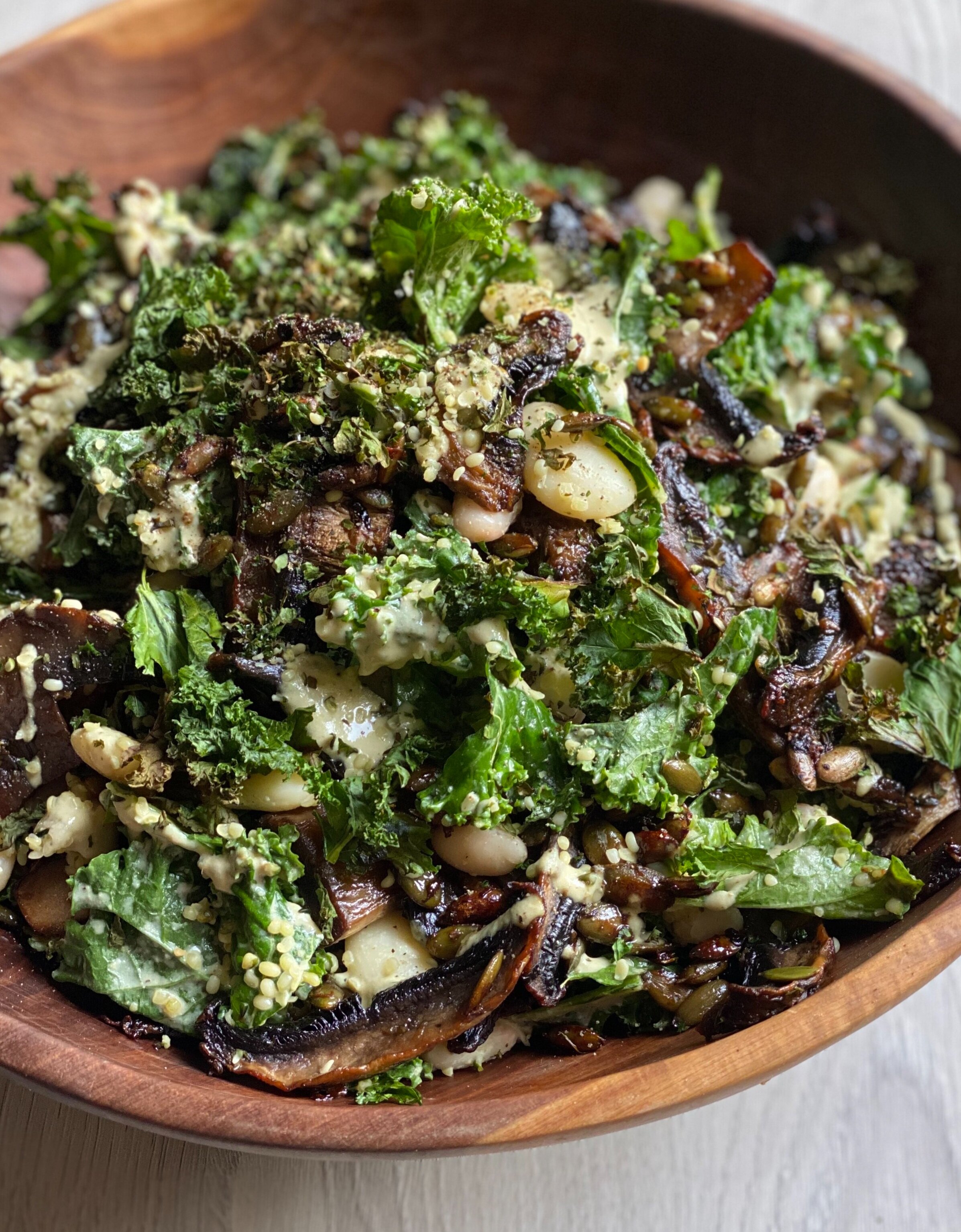 Kale and white bean caesar salad, topped with crispy kale and roasted portobello mushrooms