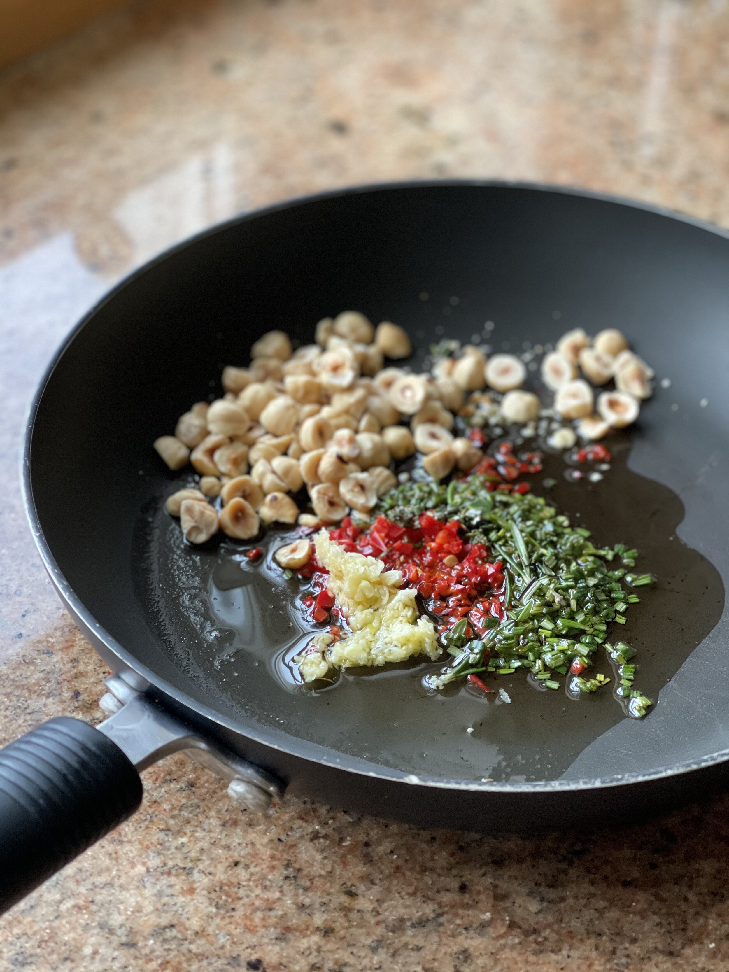 Garlic, chilli, hazelnuts and rosemary in the frying pan