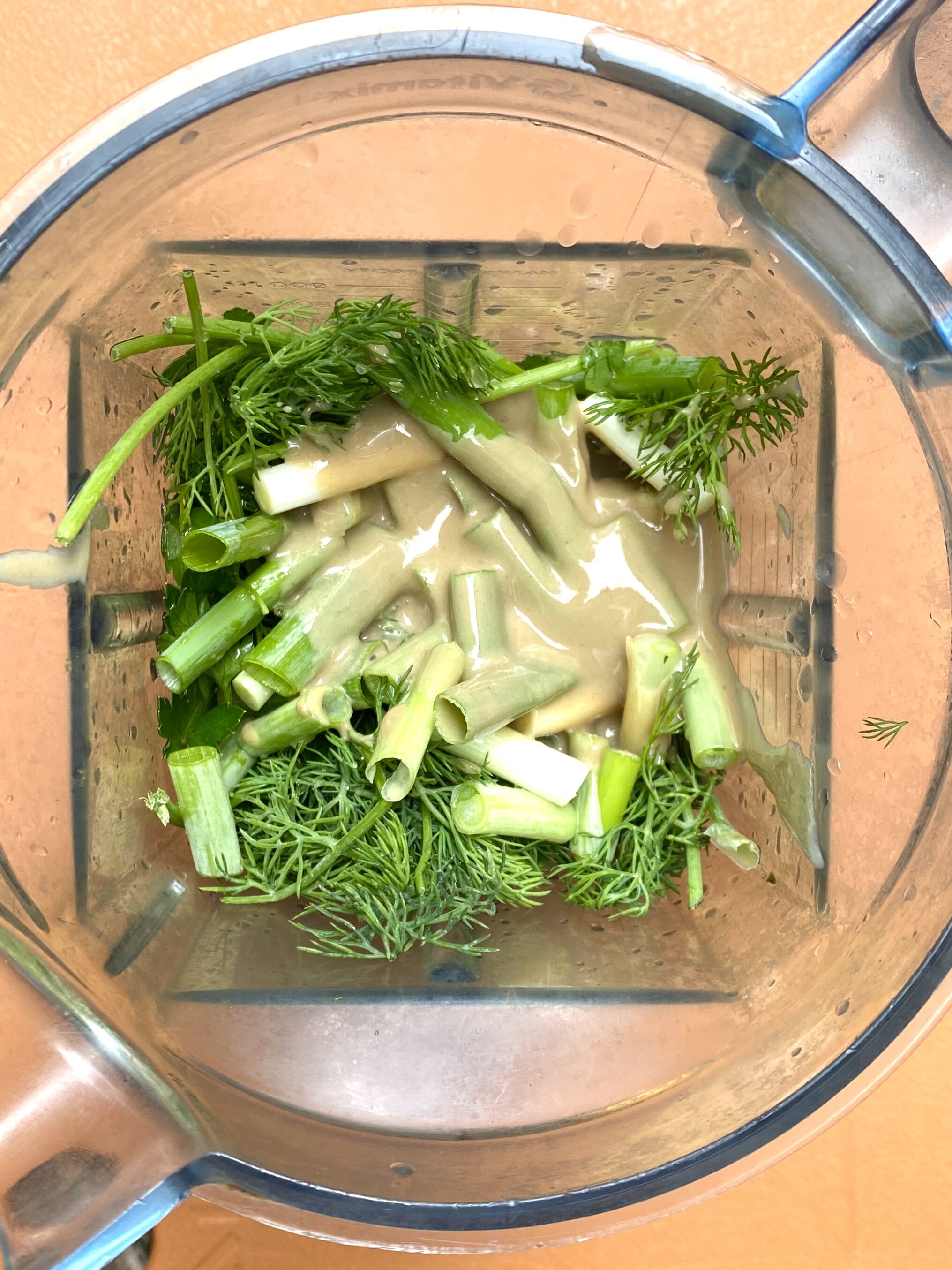 Green tahini ingredients in a blender
