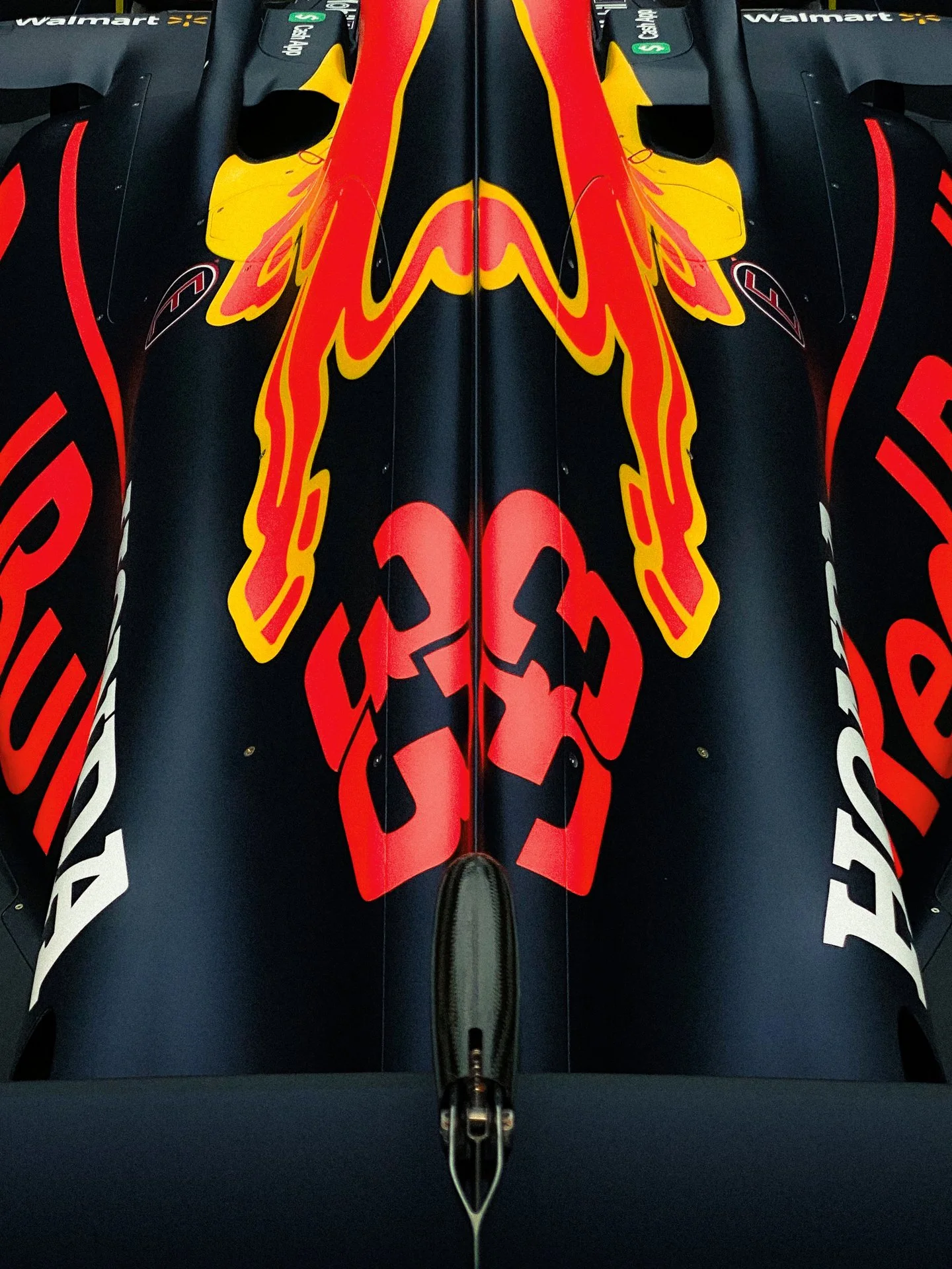 A close-up of a Formula 1 car's nose with Red Bull Racing branding, including the Red Bull logo and sponsor logos from Walmart and Tag Heuer.