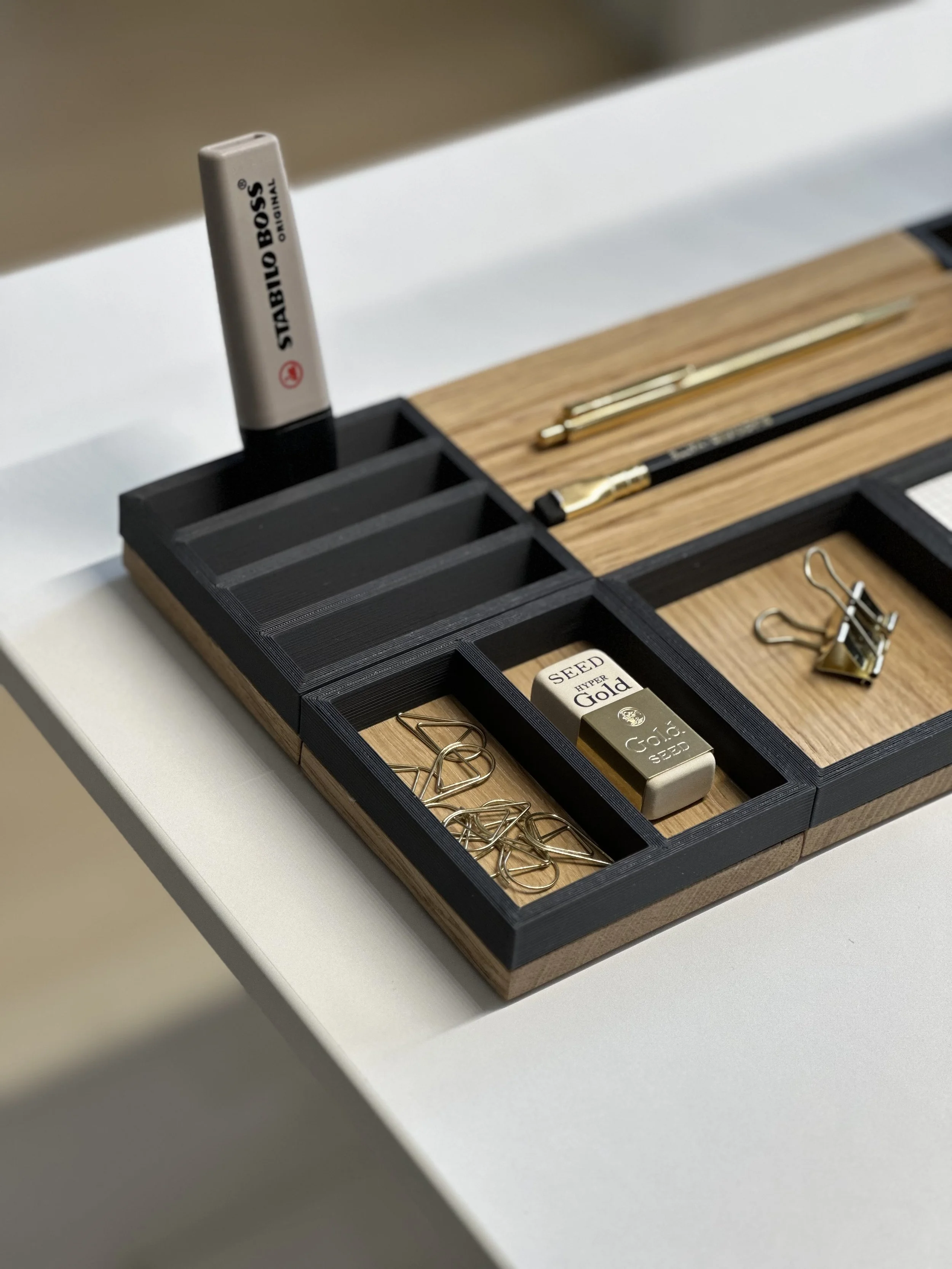 Modulare Stiftablage aus massivem Holz – perfekt für einen aufgeräumten, stilvollen Schreibtisch. Magnetisch kombinierbar, aus edler Eiche oder Nuss gefertigt und mit modernen PLA-Rahmen ergänzt.