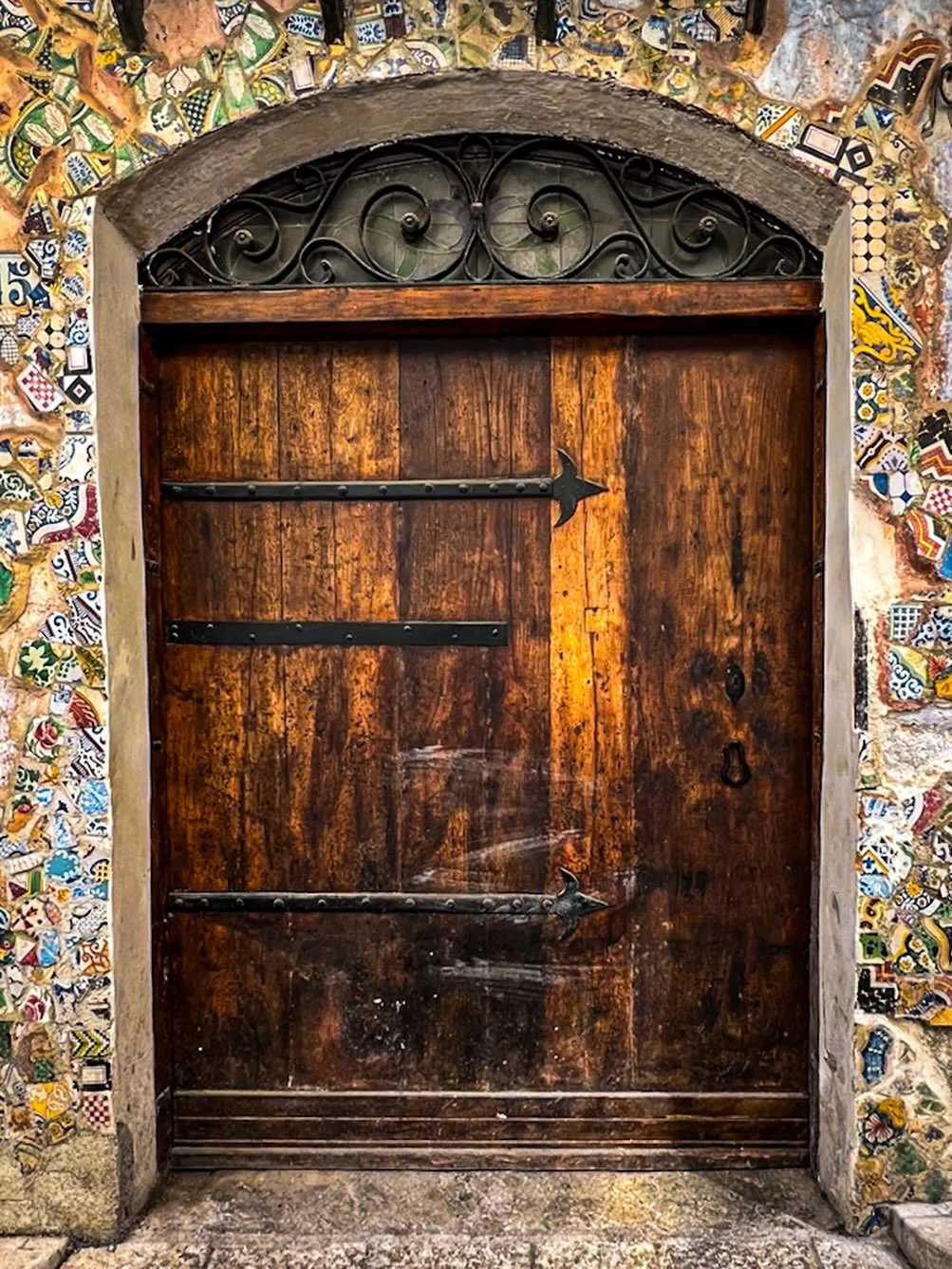 If you didn&rsquo;t already have a fascination with doors in Europe, this one we stumbled upon in Monreale, just outside Palermo, might start one.
Old wood. Broken tile art.
A doorway holding history, creativity, and an unapologetic Sicilian sense of