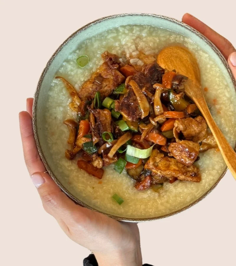 A bowl of warm postpartum food held in two hands