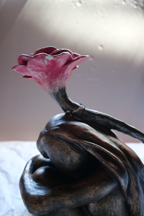 A close-up of the sculpture, showing areas of loss around on the petals and a crack in the stem above the head. Bunjil Place. © Tiaki Objects Conservation.