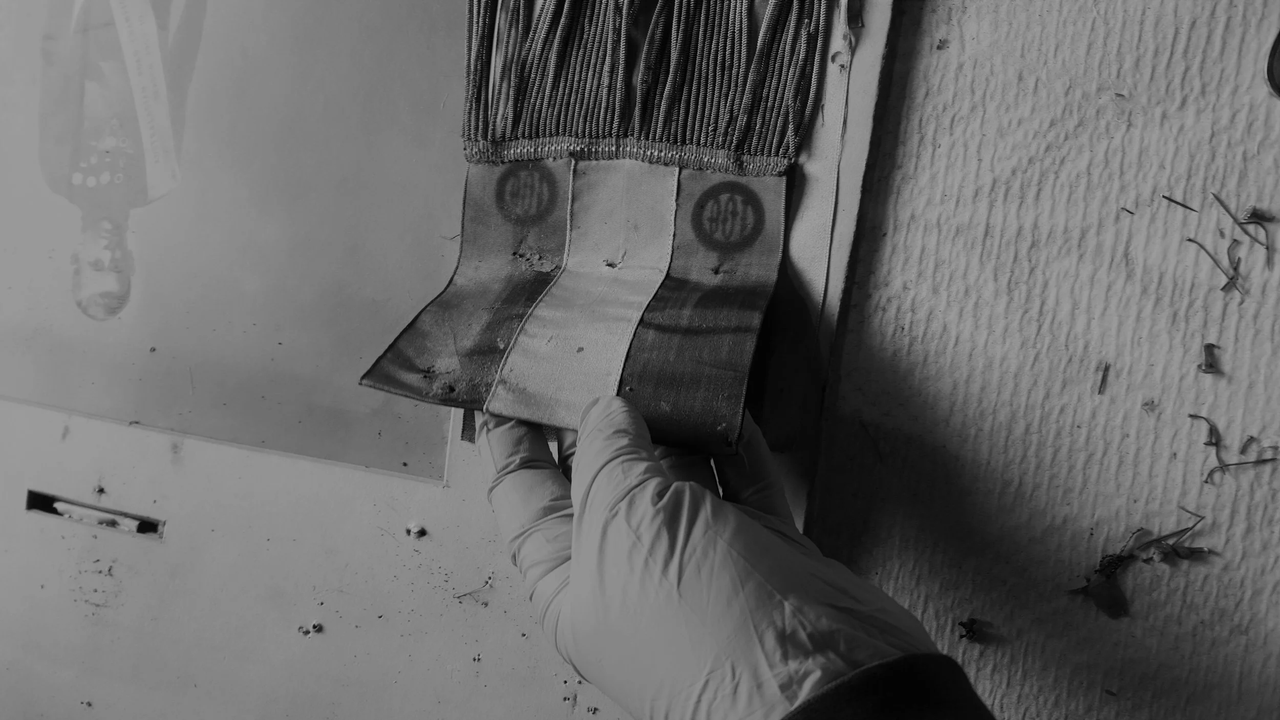 Close-up of gloved hands handling a textile cultural object during conservation treatment