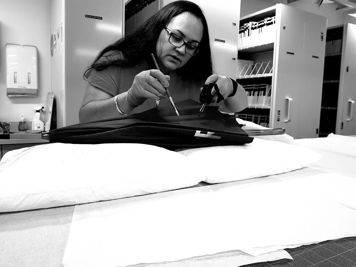 Objects conservator undertaking detailed conservation treatment on cultural material in a collection setting