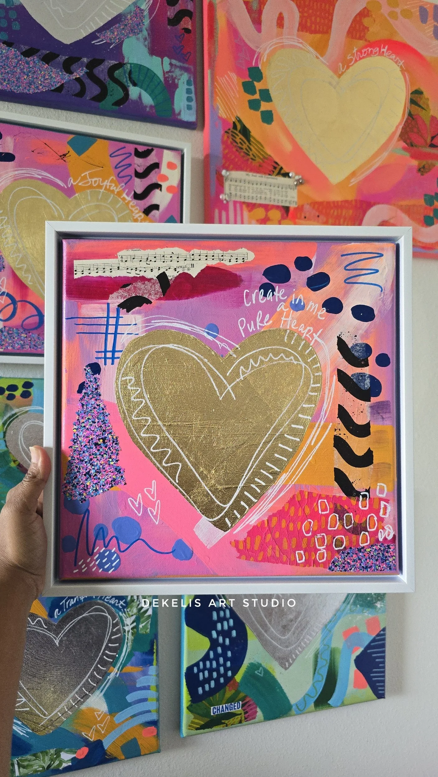 Colorful mixed media abstract painting in a white frame.