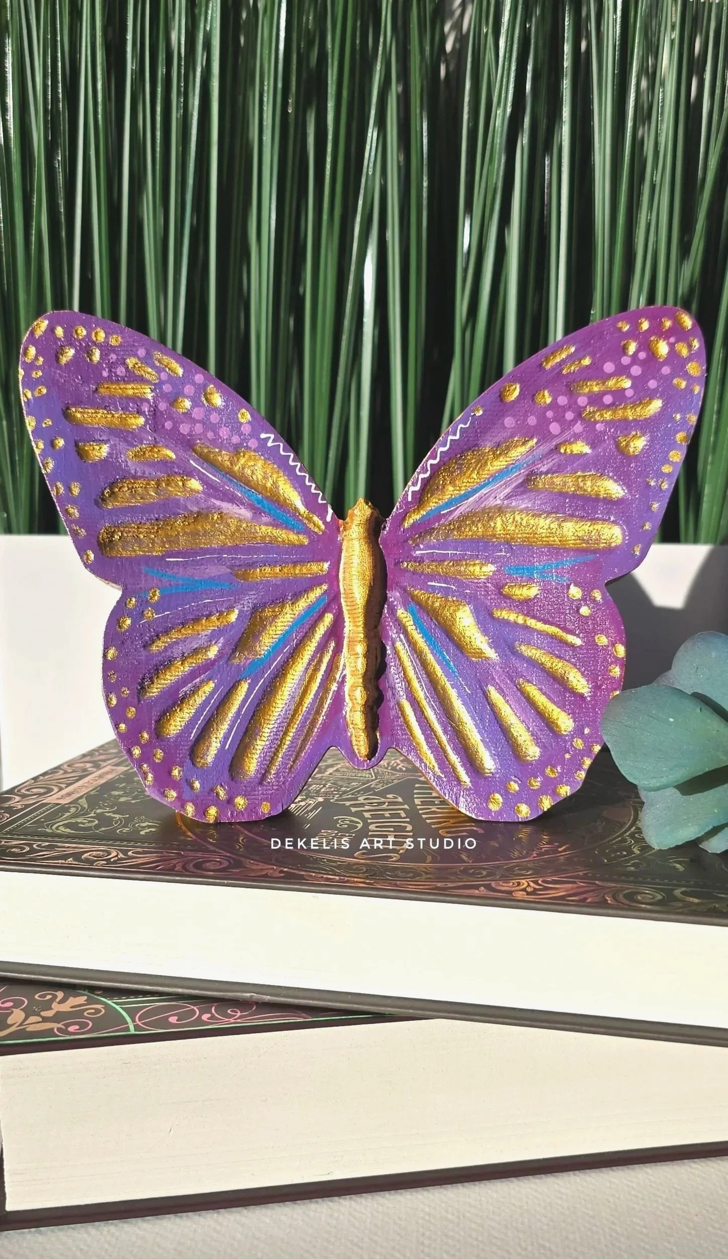Brighten any space with this hand-painted wooden butterfly, finished in shimmering metallic gold, warm orange, coral, soft yellow and white.