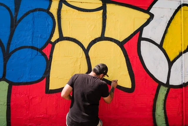 San Antonio contemporary artist, Albert Gonzalez, patiently hand paints a vibrant large scale mural