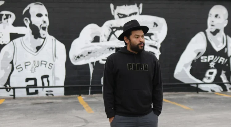 Albert Gonzales stands in front of a spurs mural he created.