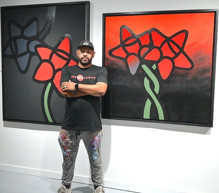 Albert Gonzales stands in front of two wabi sabi artworks.