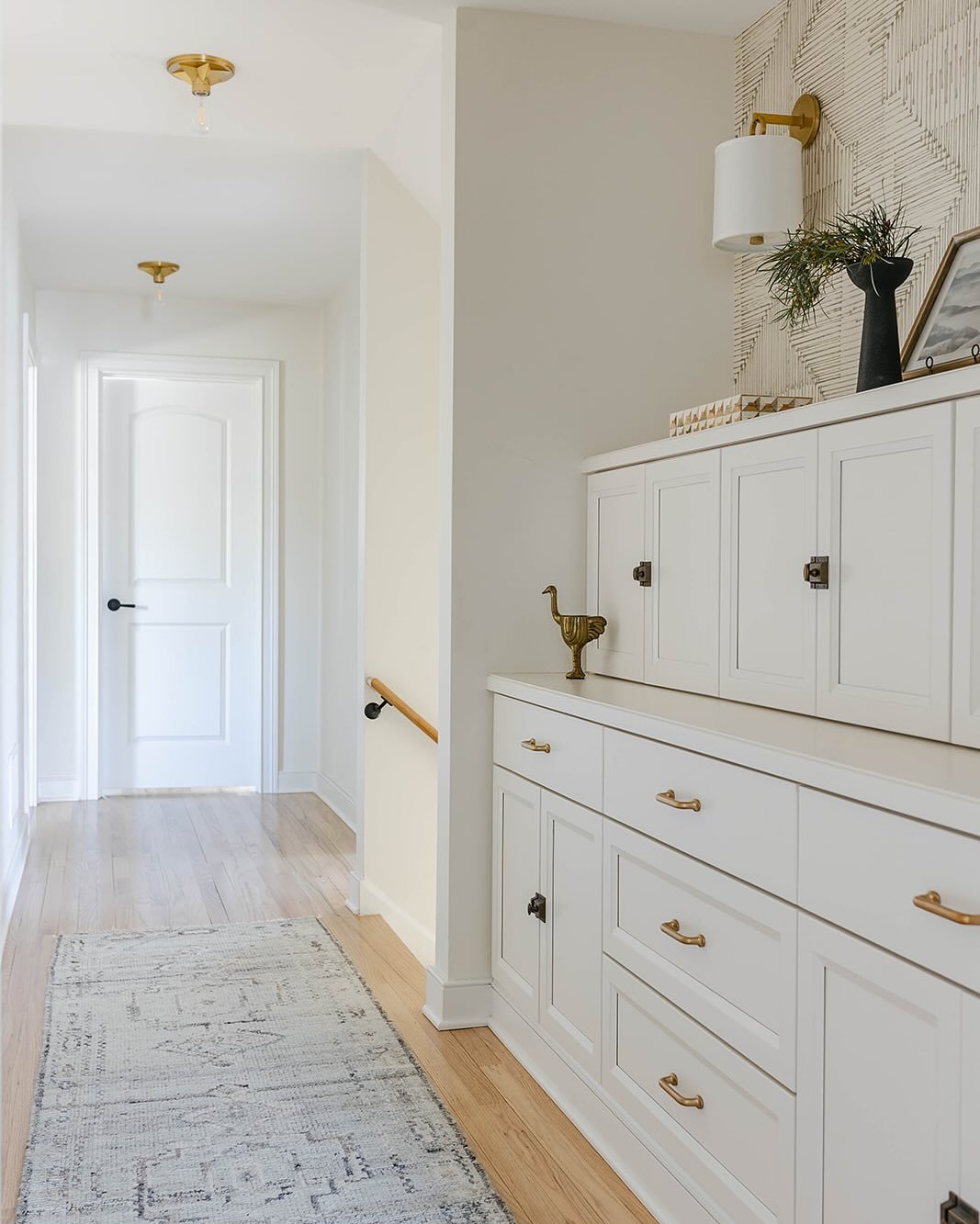 This used to be a hallway of doors. It lacked character and felt like an unforgotten area of the home. ➡️ to see before. 

We removed the closet and designed custom built-ins to create a sense of space as you enter the primary suite, while maintainin