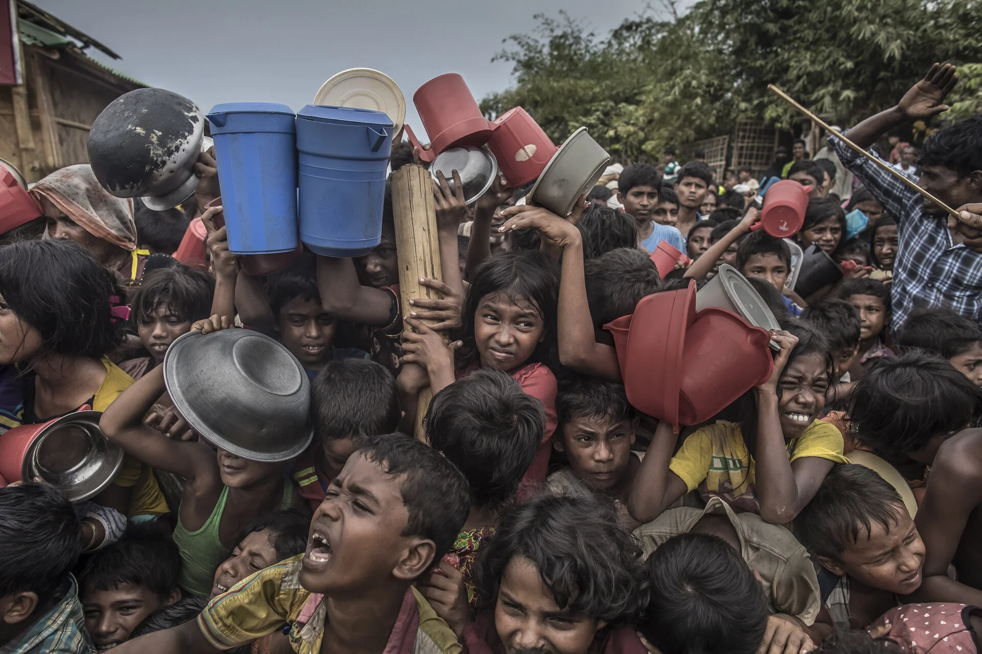 Children being beaten with a cane as they fight for food at the Balu Khali 2 refugee camp in southern Bangladesh.