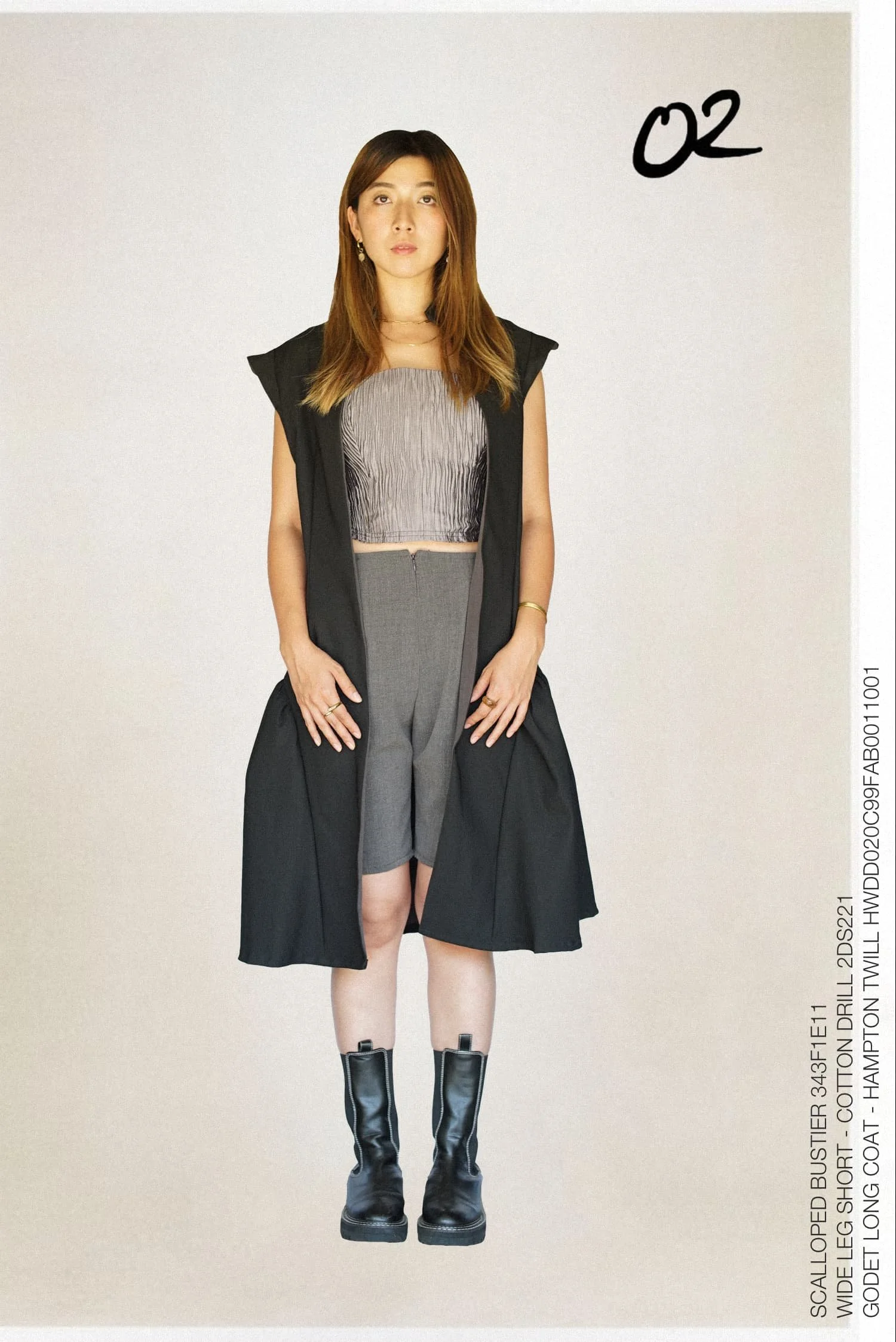 Model wearing a black tailored coat and gray separates from Keagan Roberson.