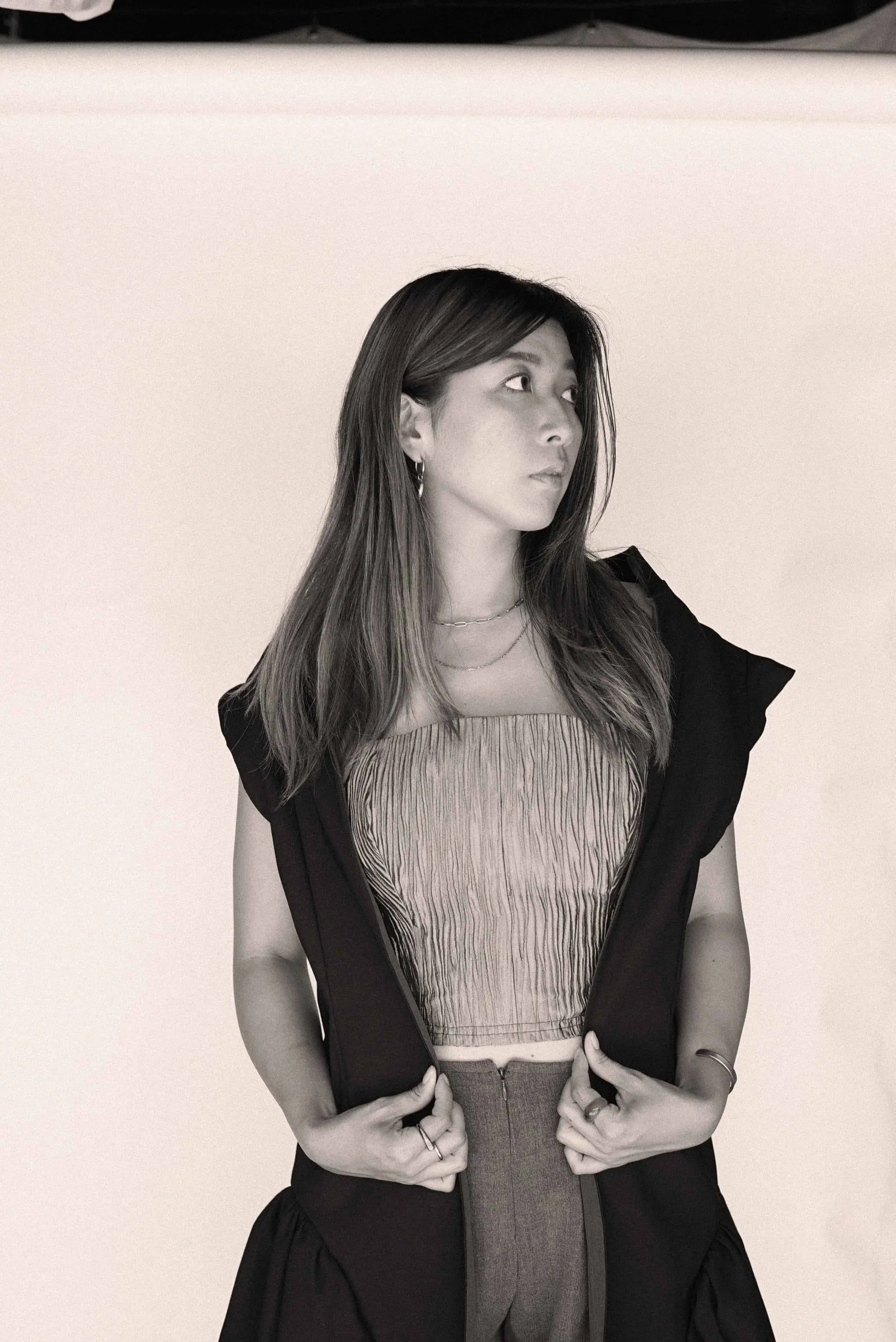 Black-and-white portrait of a model wearing layered jewelry and a strapless look from Keagan Roberson.