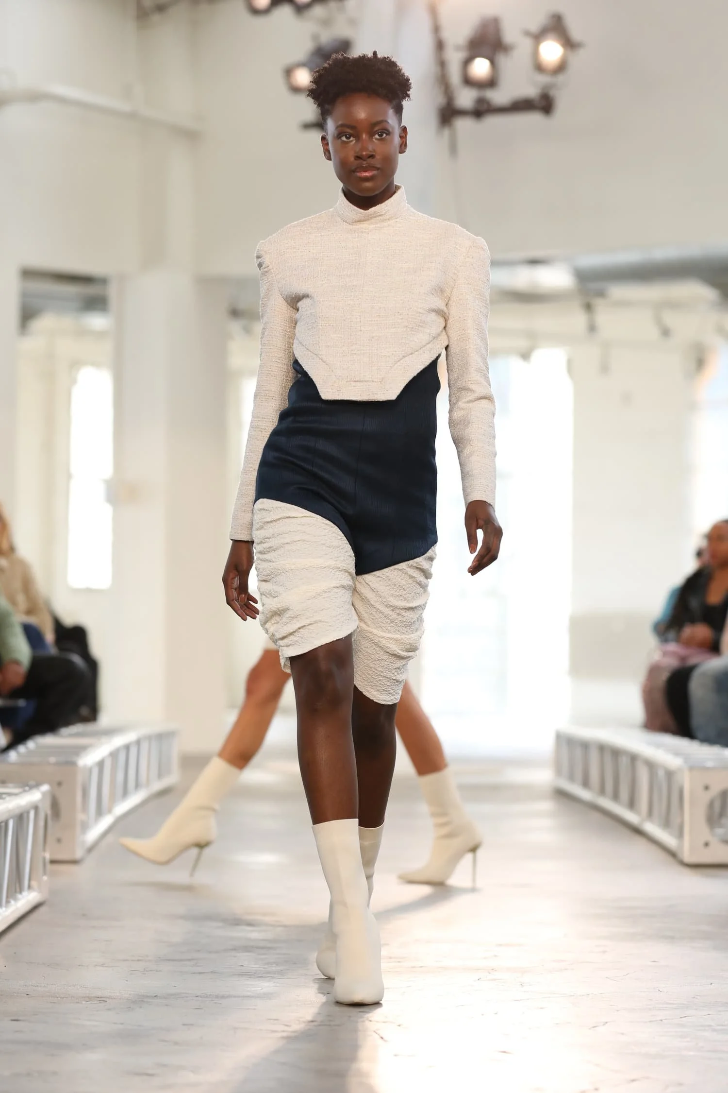 Female model walking on runway wearing Keagan Roberson.