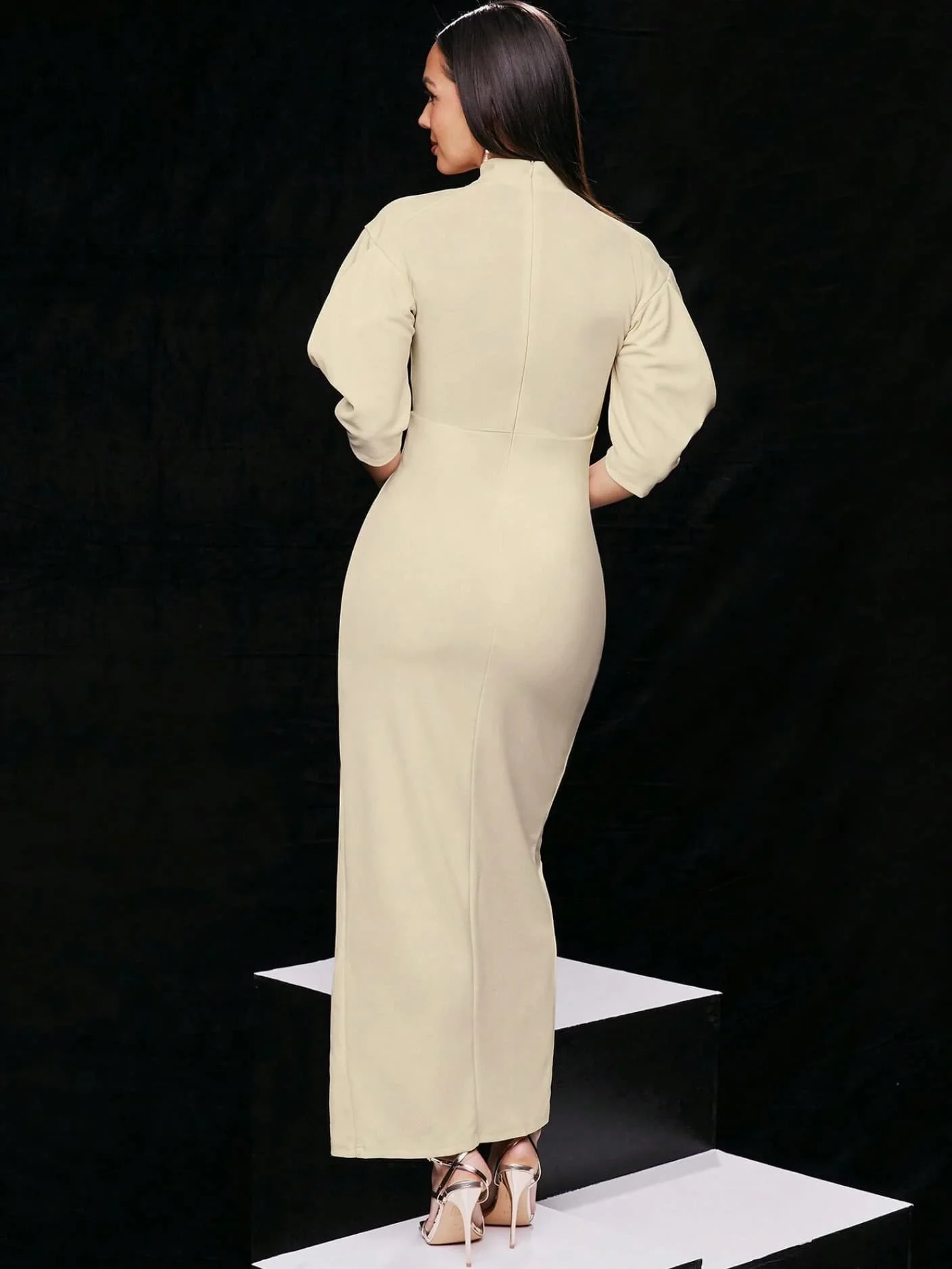 Model wearing a slit beige gown and heels from Keagan Roberson.