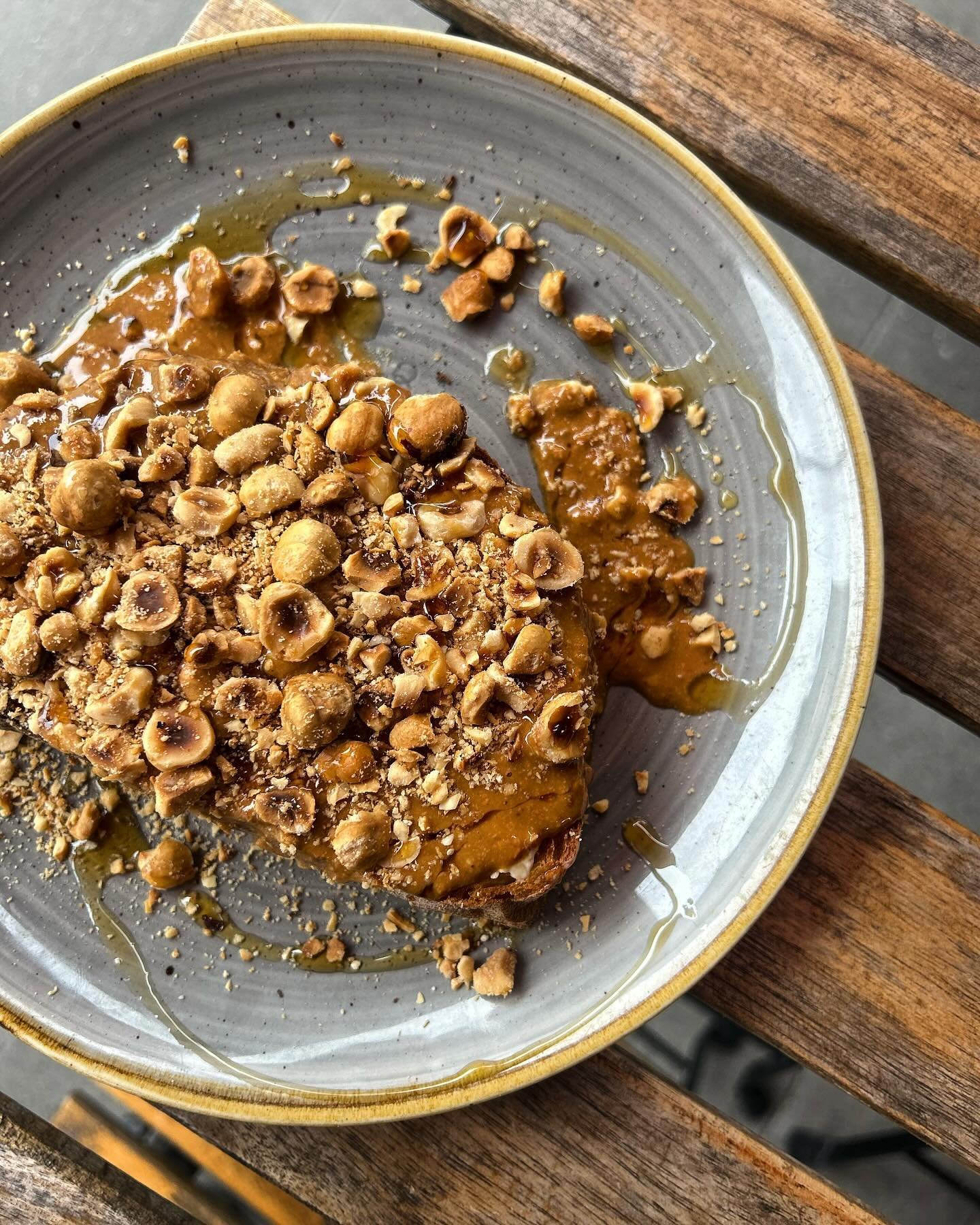 Sourdough toast slathered with housemade hazelnut butter, maple syrup and roasted hazelnuts plated so beautifully by our wonderful chefs 🌰