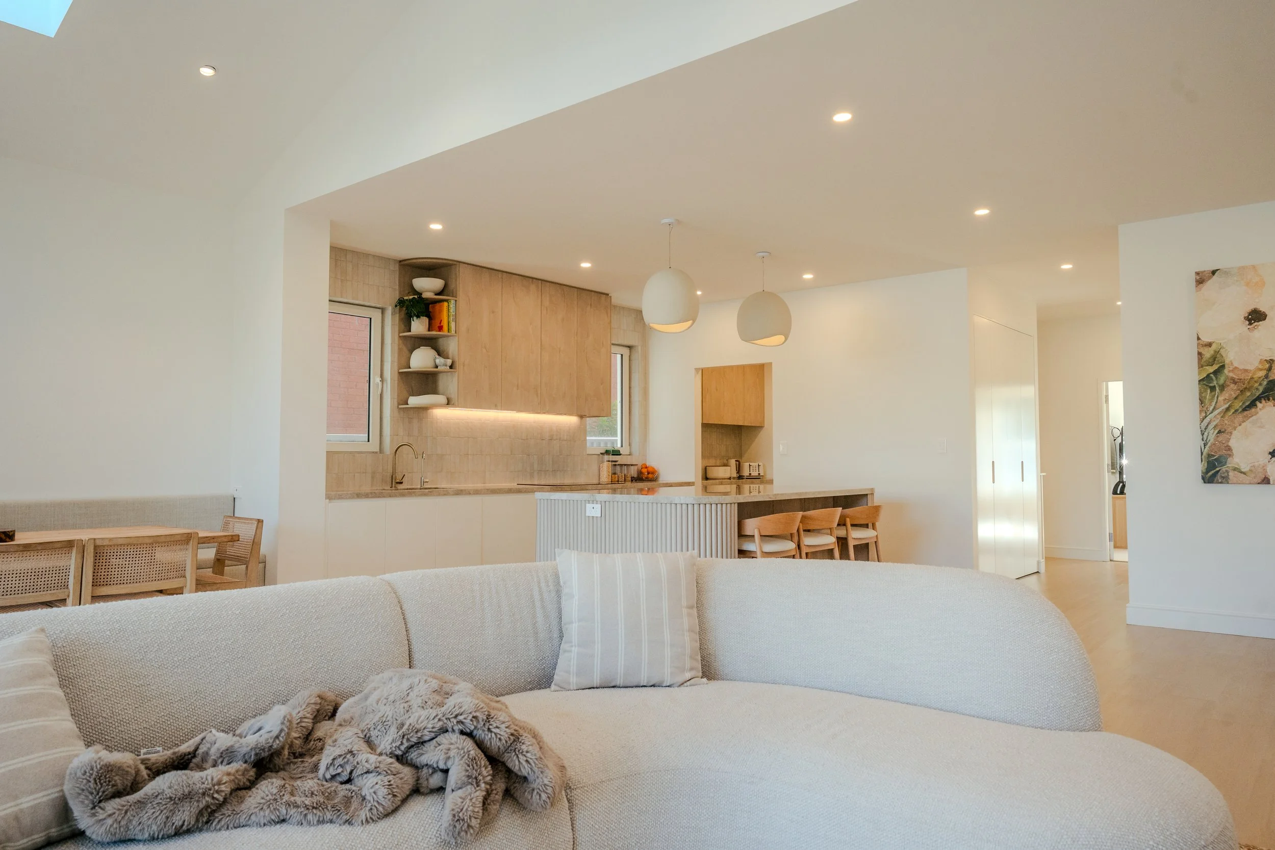 Modern renovated living and kitchen area with neutral tones and wood finishes