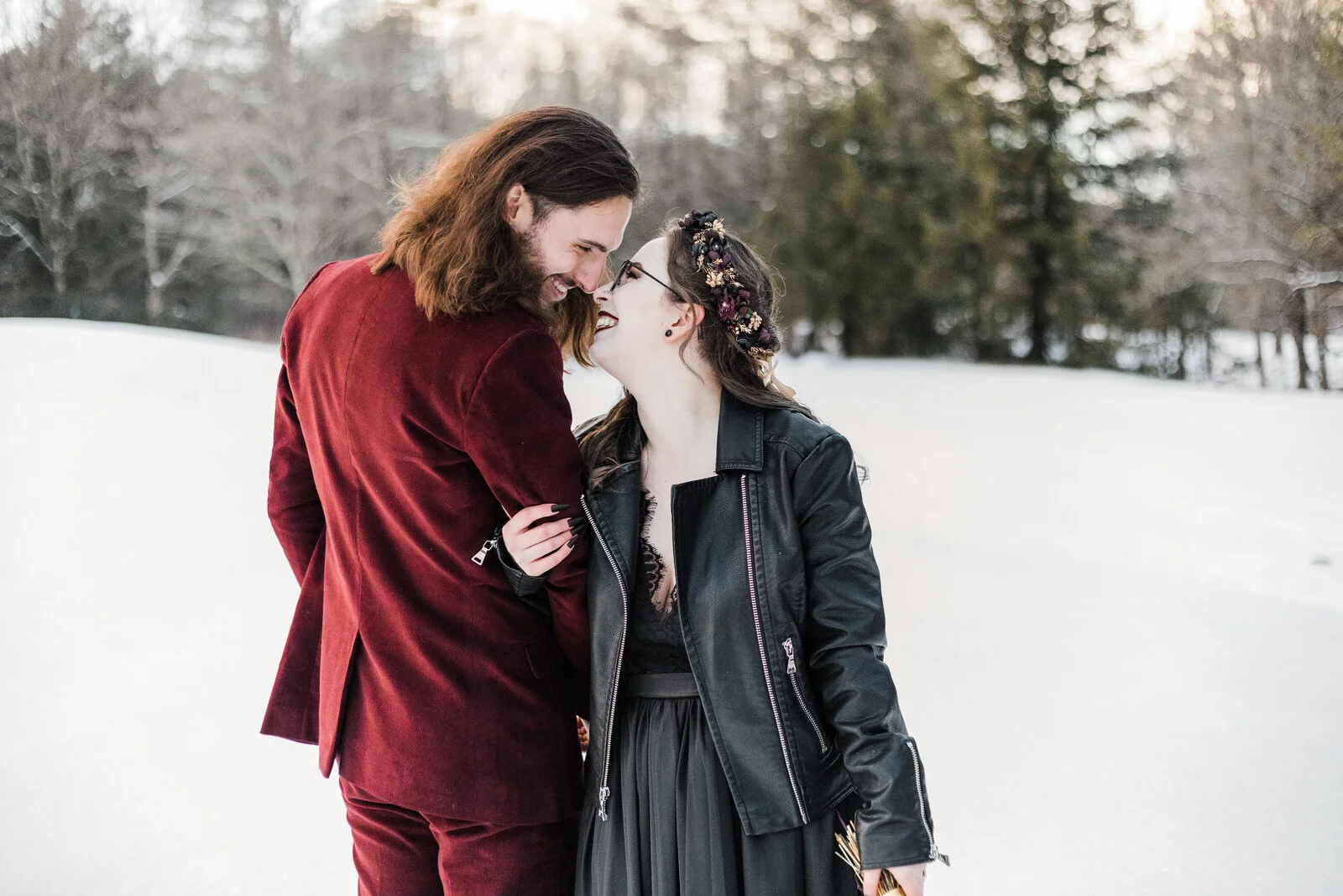bride-in-black-wedding-dress-groom-in-burgundy-suit-in-snow.jpg