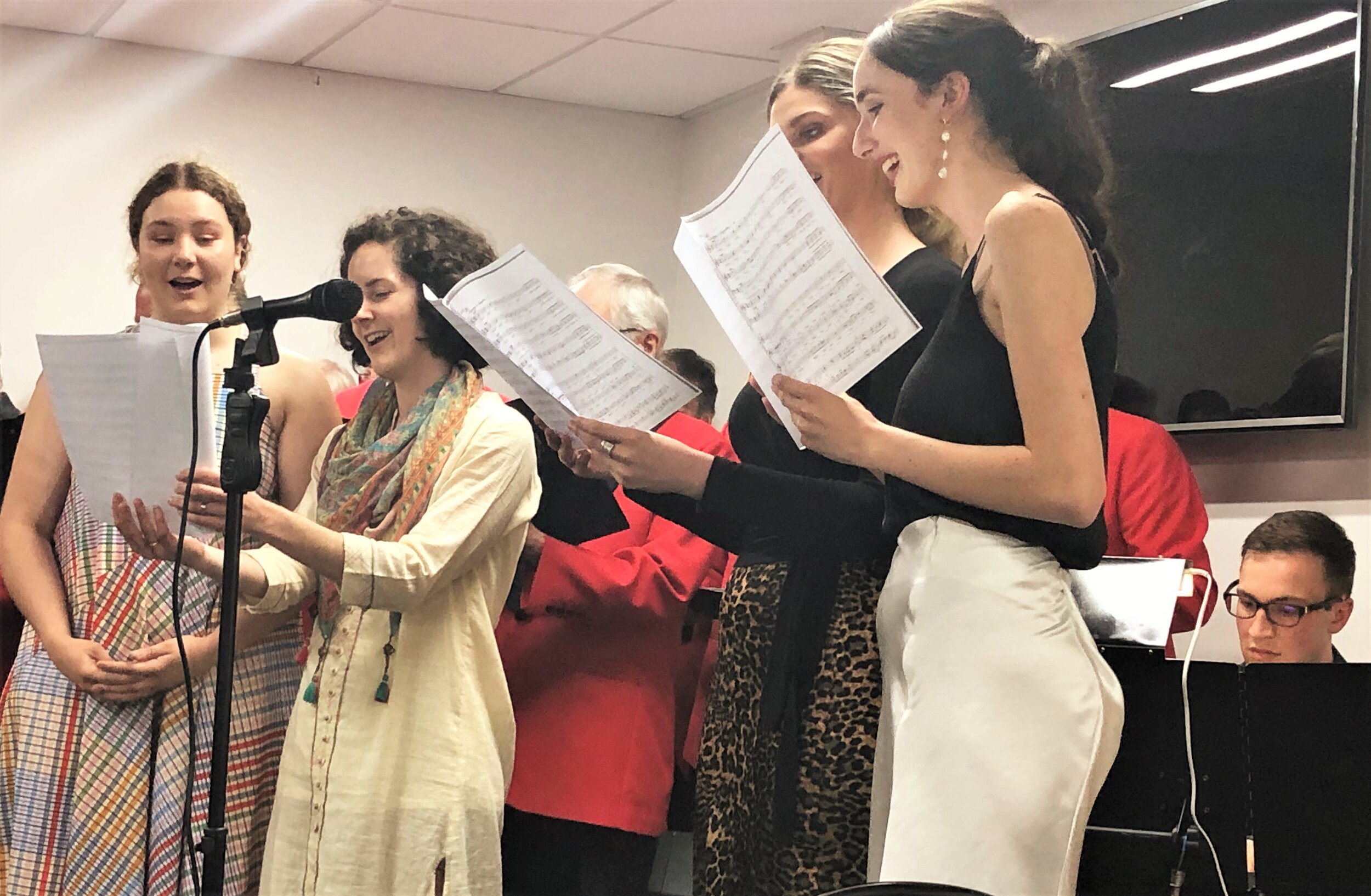 Lillian, Tessa, Rhiannon and Emma singing with the choir with Mark playing the piano.
