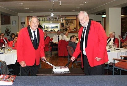 David Christie, one of the longest serving members, and Neil Grant, one of the newest members, cutting the cake.