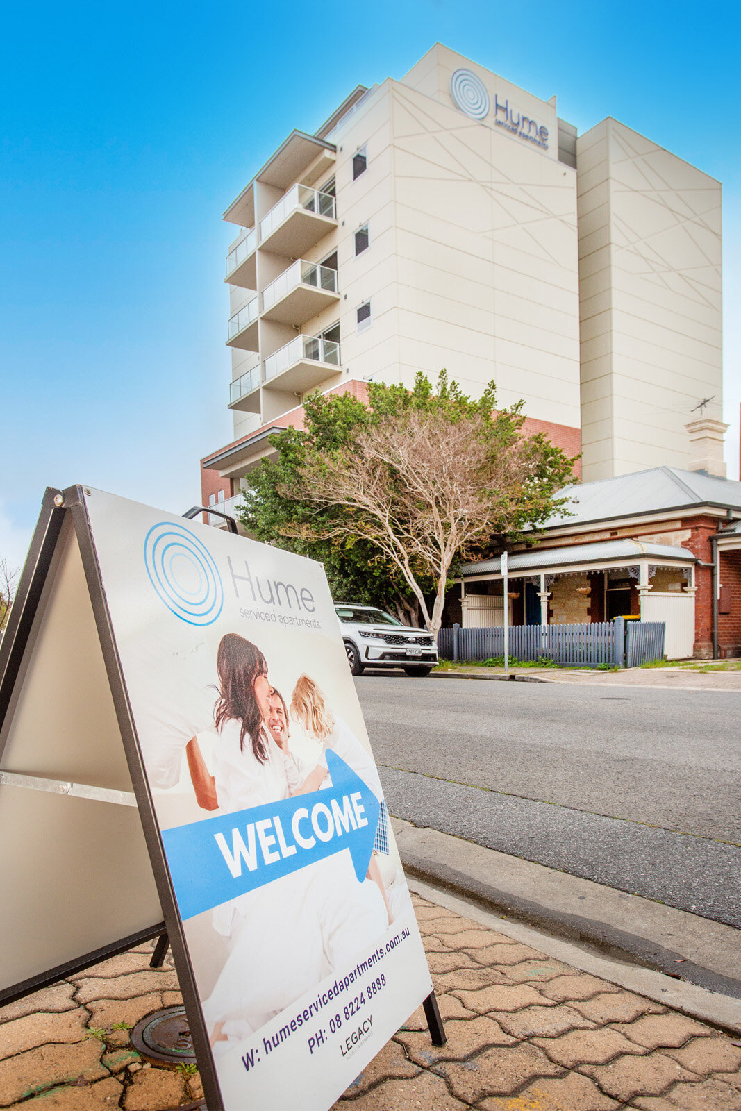 Hume serviced apartments building with a welcome sign in the foreground.