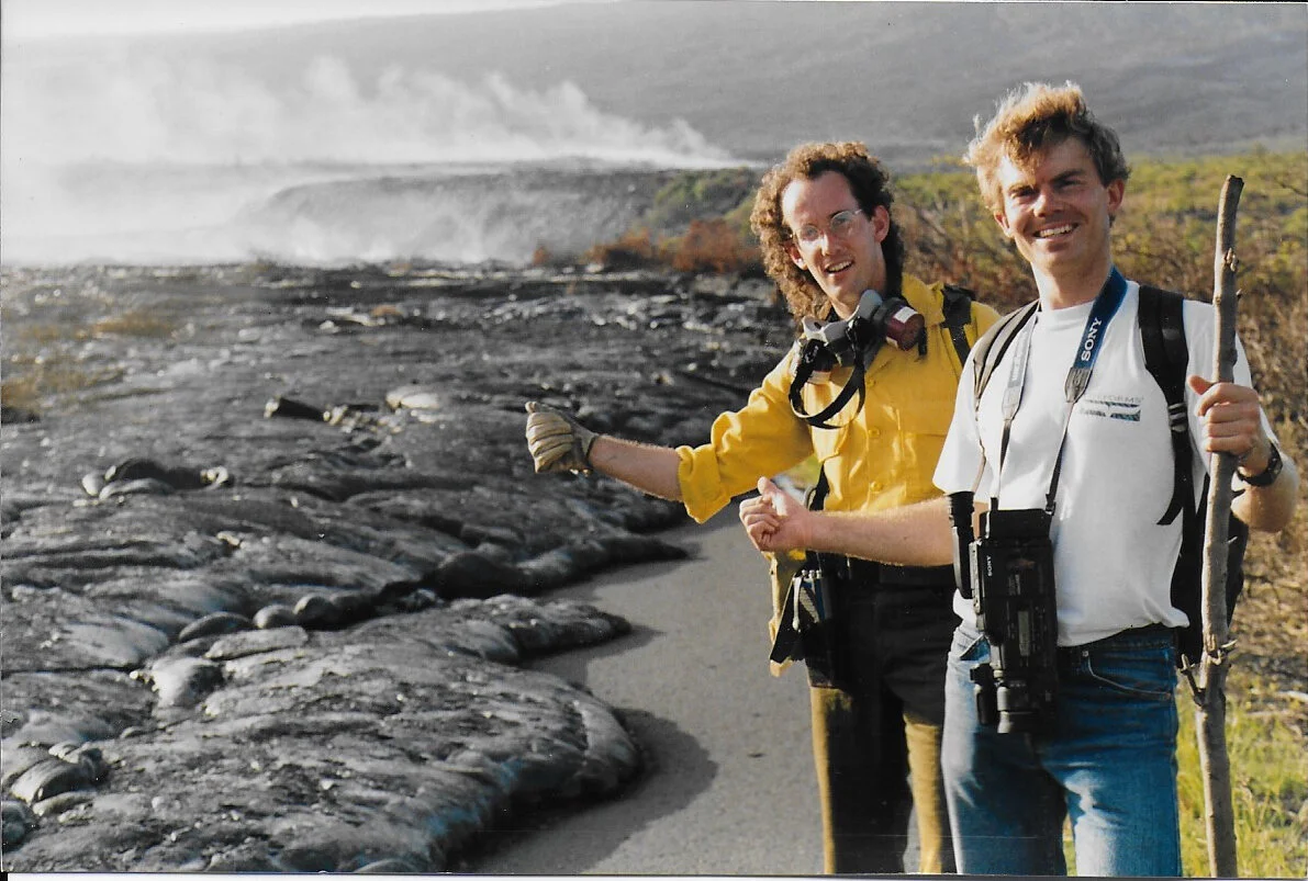 Greg (left) in nomex shirt standing next to an active lava flow field at Kamoamoa.