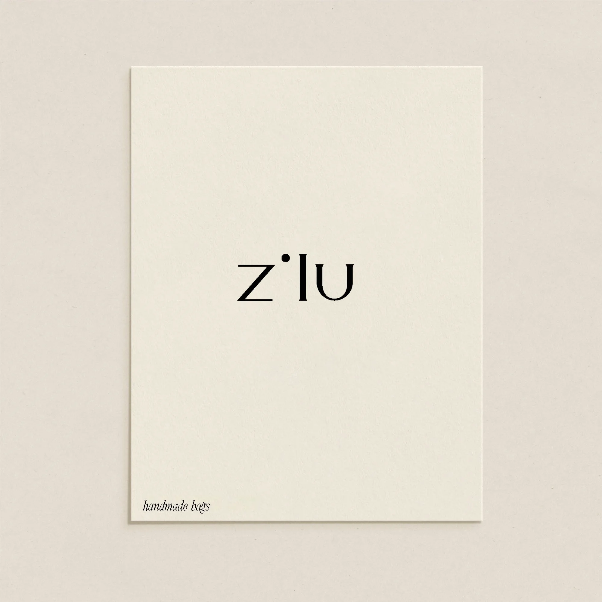 Plain white card with black text reading 'zilu' in bold as a brand design element for a fashion brand
