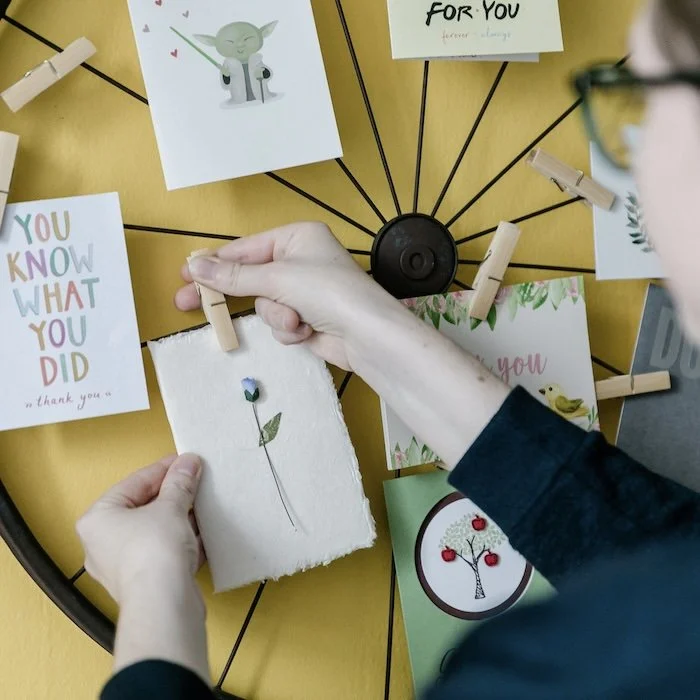 Kati Carrapa clipping a postcard onto a display