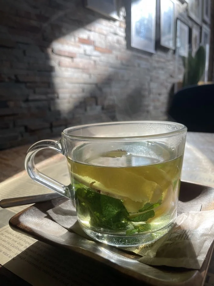 Glass mug of mint tea with fresh mint and lemon peel