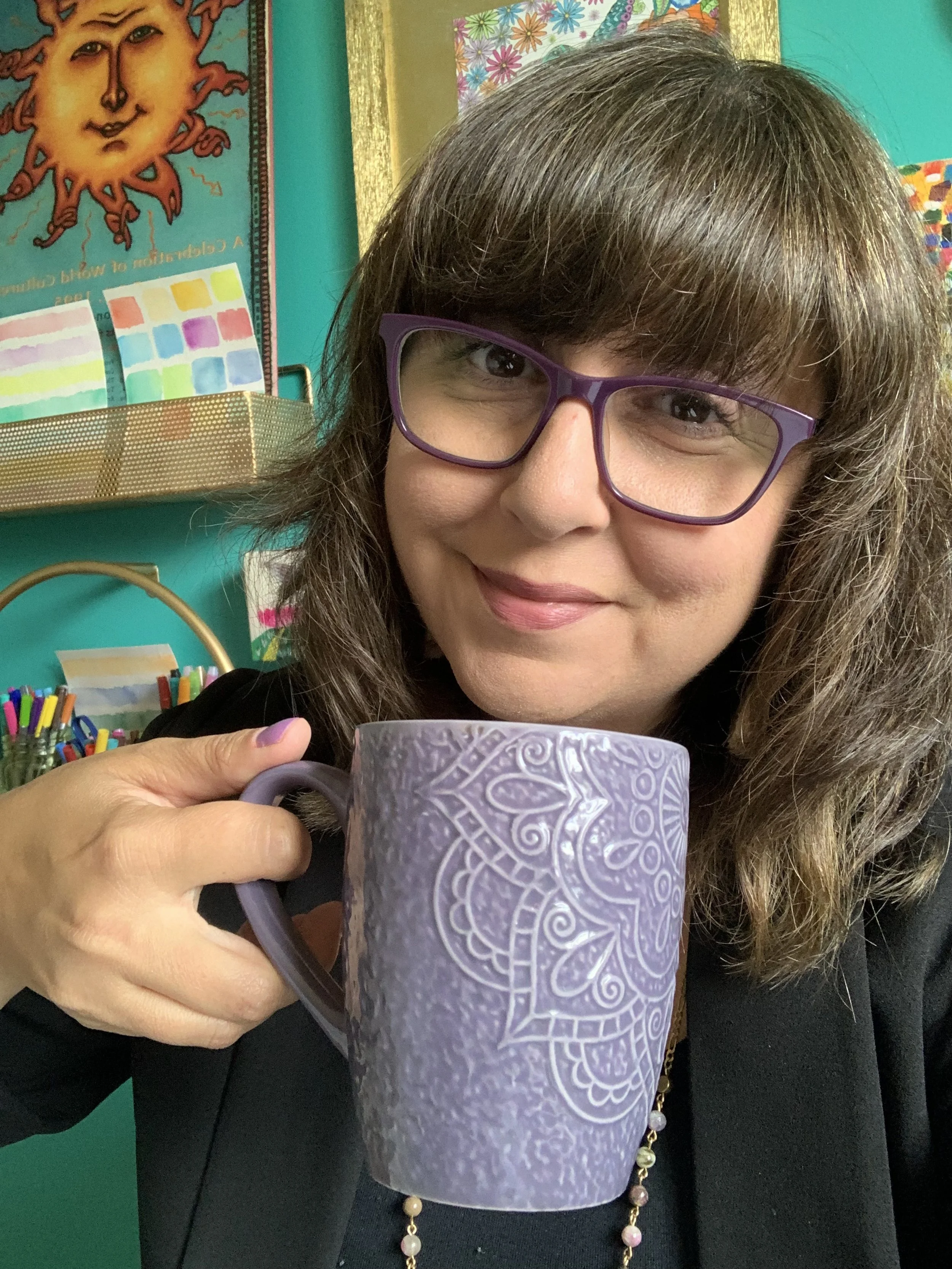 Janic in her home office holding a purple coffee mug