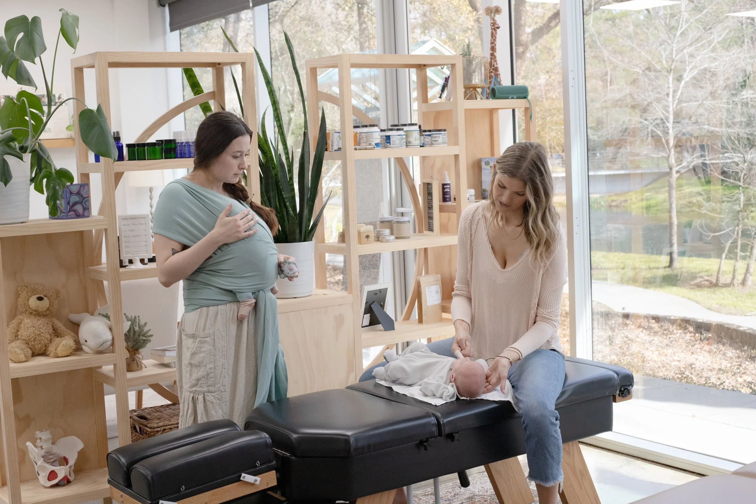 Pediatric chiropractor helping baby with gentle alignment during family wellness visit in north Houston