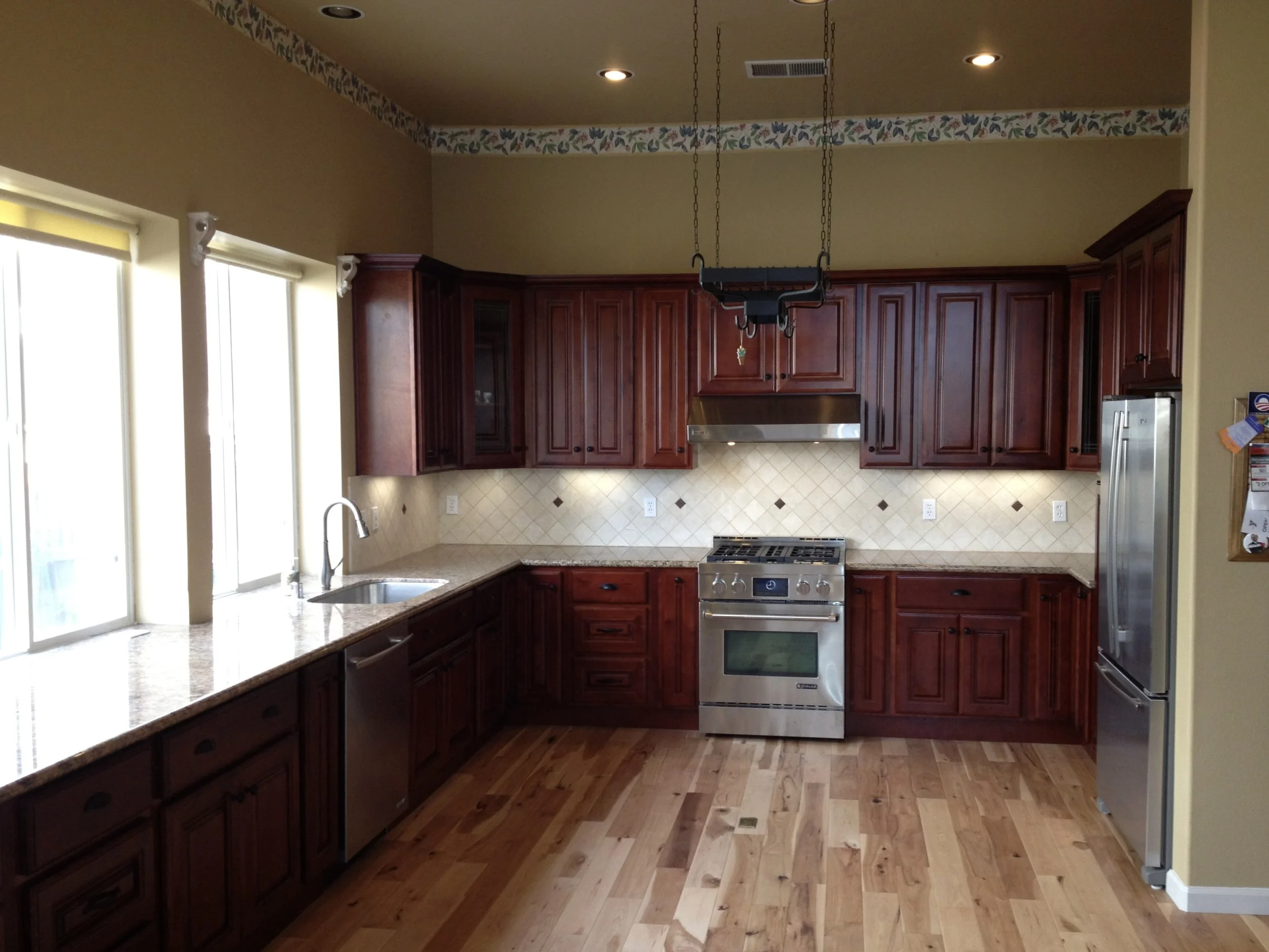 This kitchen was a remodel with solid wood cabinets, hickory floor, and repiping for gas. Oversized granite was used to accommodate counter height windows. 
