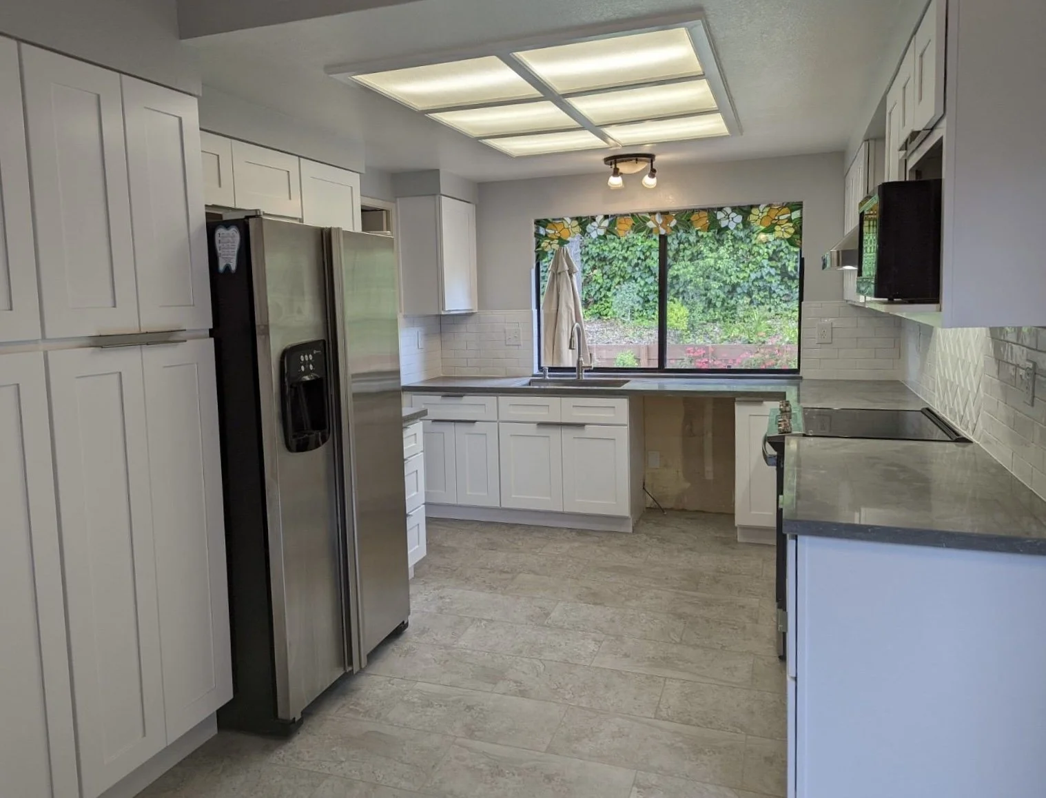 This was a transformation of a 1980s kitchen on a budget. Included new flooring, countertops, and lighting adjustments to modernize the kitchen.