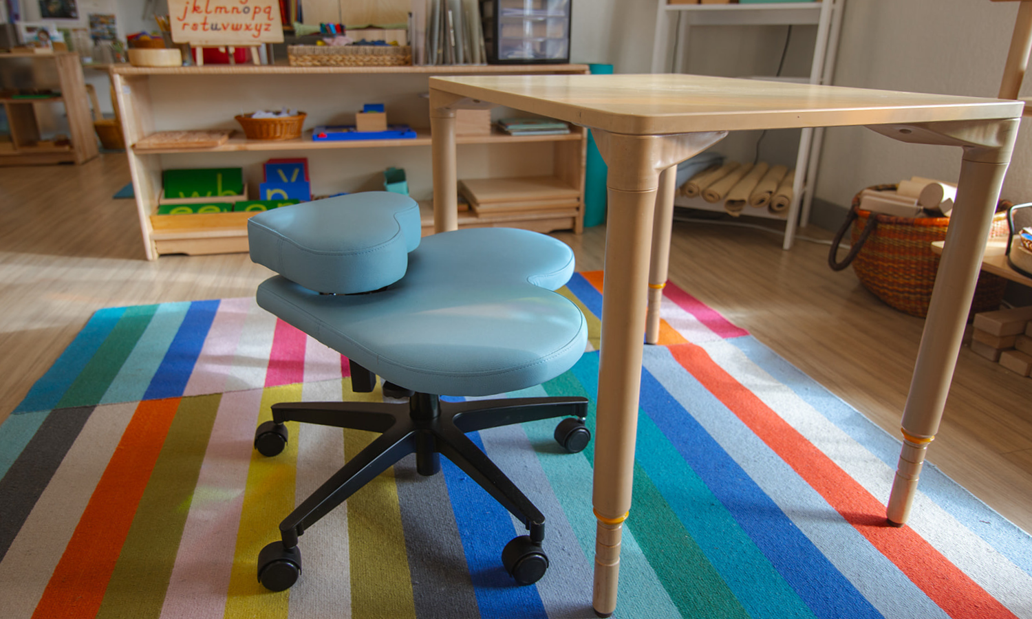blue Fidget seat for kids at a small table in a classroom with colorful rug