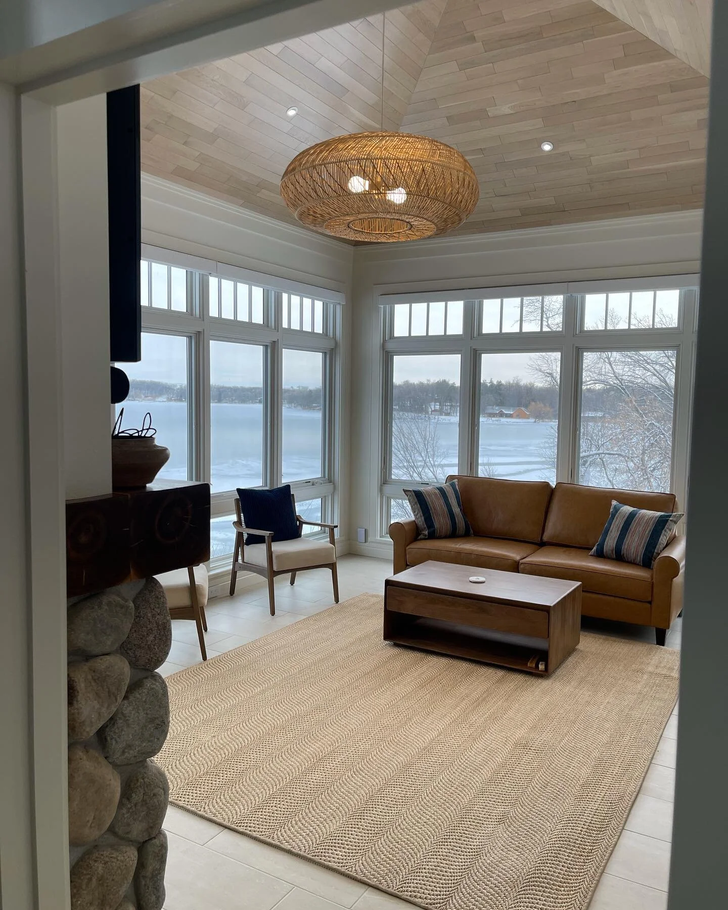 The lake may be frozen, but this sunroom is a warm and cozy place to enjoy the view (and the fire).