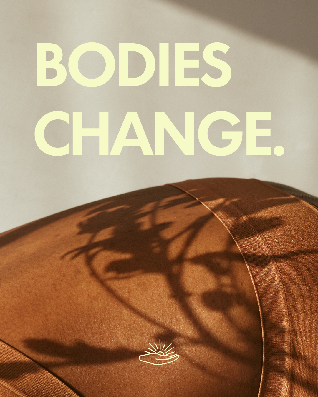 Text reading 'Bodies Change.' over a background of brown fabric with shadow of plant leaves and a small white logo of a hand with a radiant sun above it.