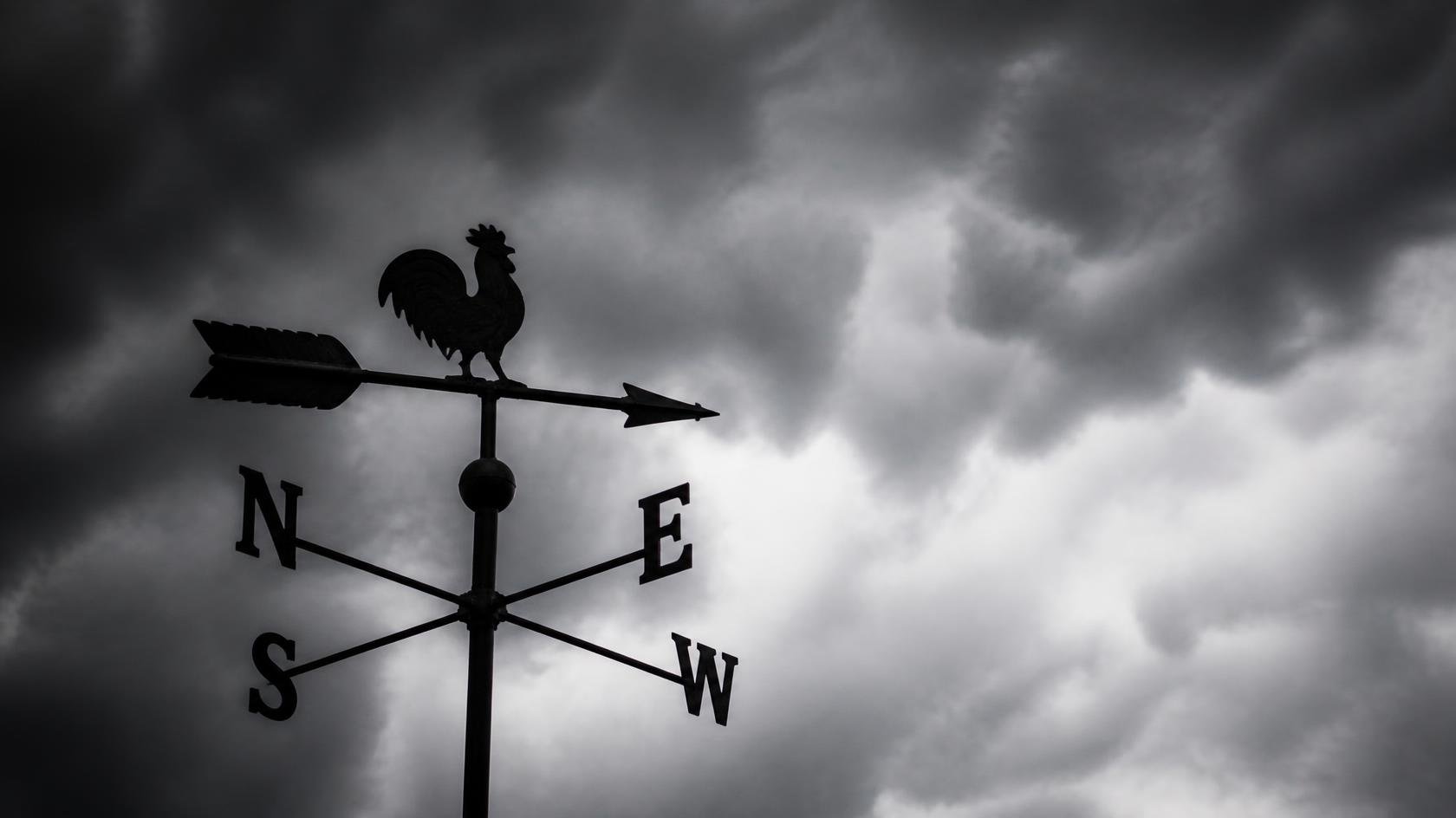 weathervane against a stormy sky background - representing moving where the market wind blows when one is without an investment policy statement