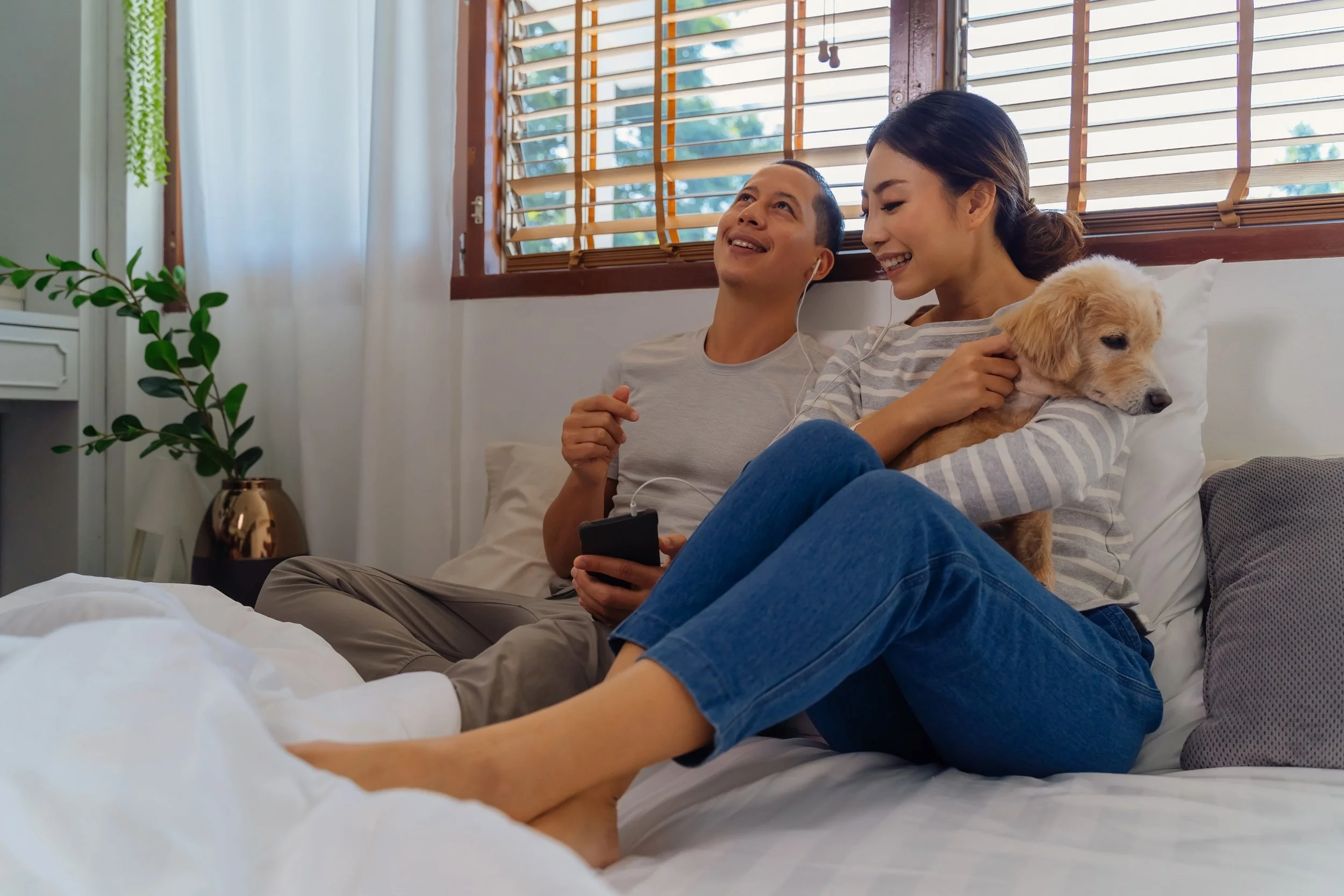 A couple relaxing at home with their dog, representing DINK (dual income, no kids) financial planning in Singapore