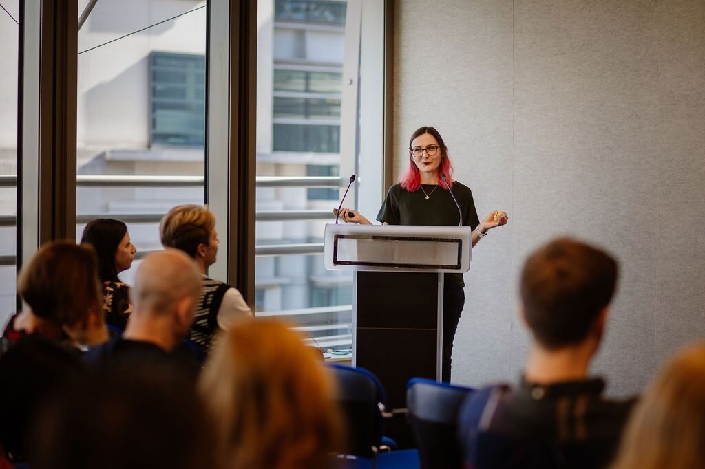 Expand the Circle founder Alicja Nocon standing behind a podium speaking to an audience at an event