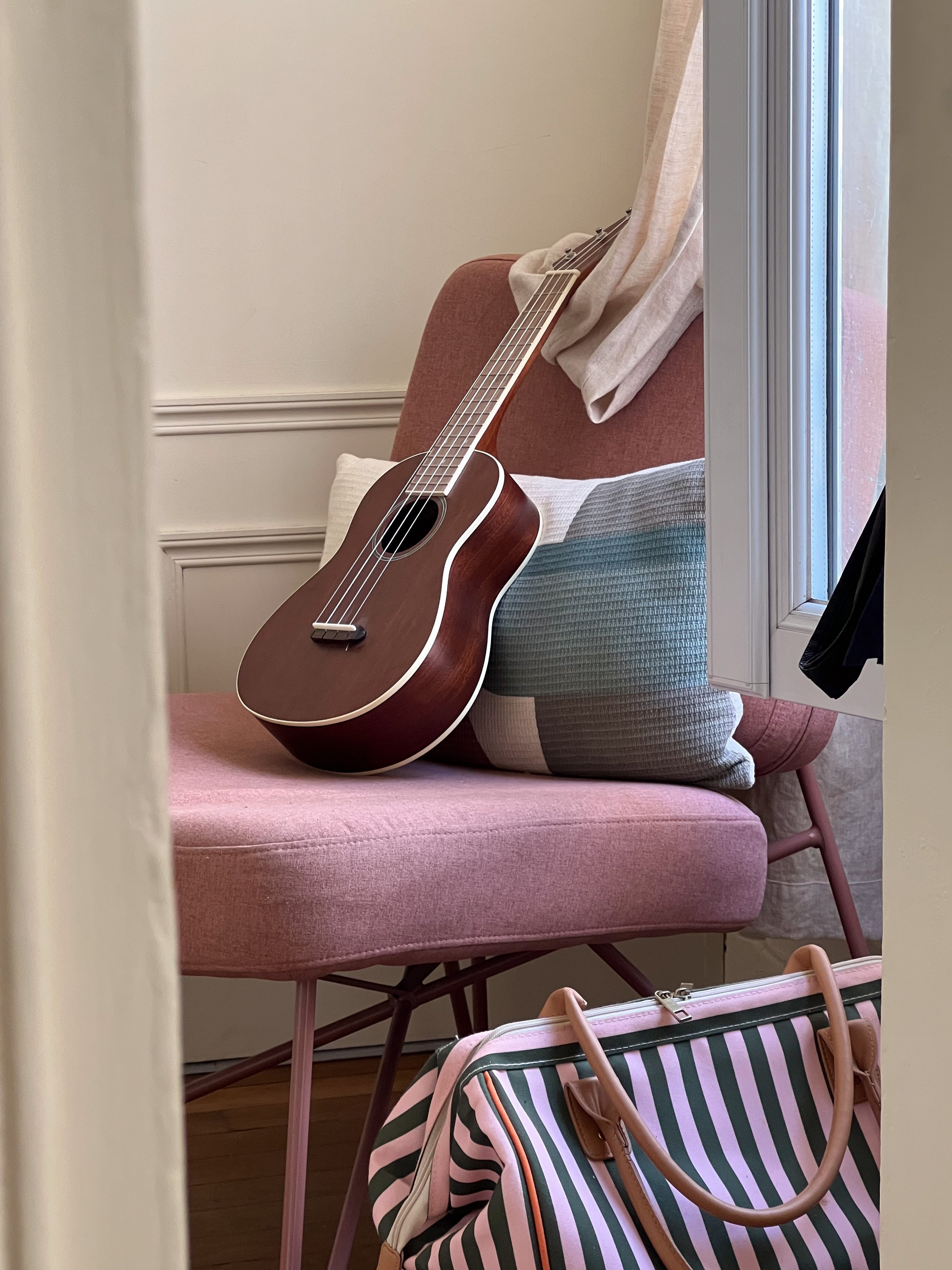 Ukulélé élégant assis sur une chaise dans la chambre