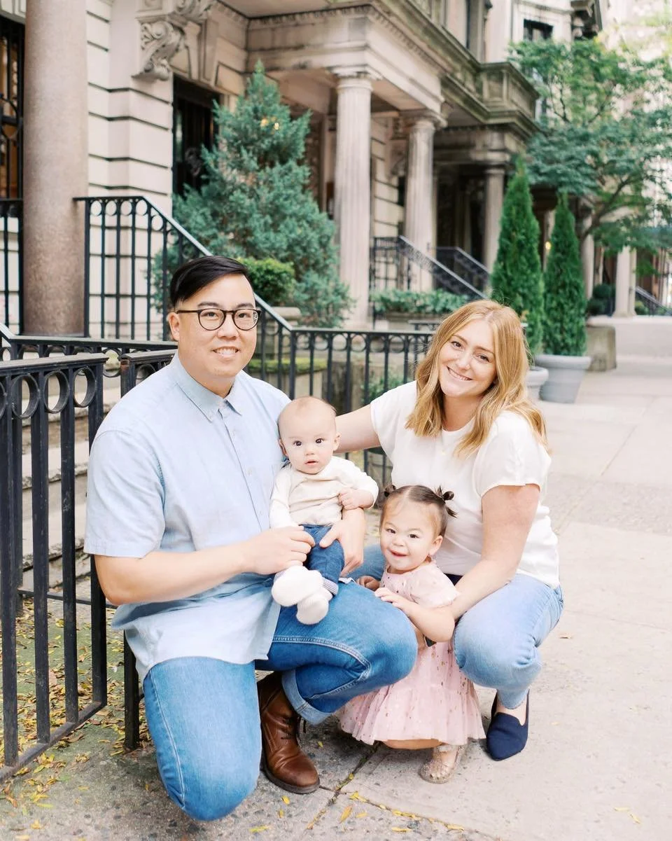 P.S. don&rsquo;t forget to bring me on your travels, cause you might end up with family photos in a cool city!

Family of four with two young children sitting together on a city sidewalk in New York City, smiling in front of classic brownstone buildi