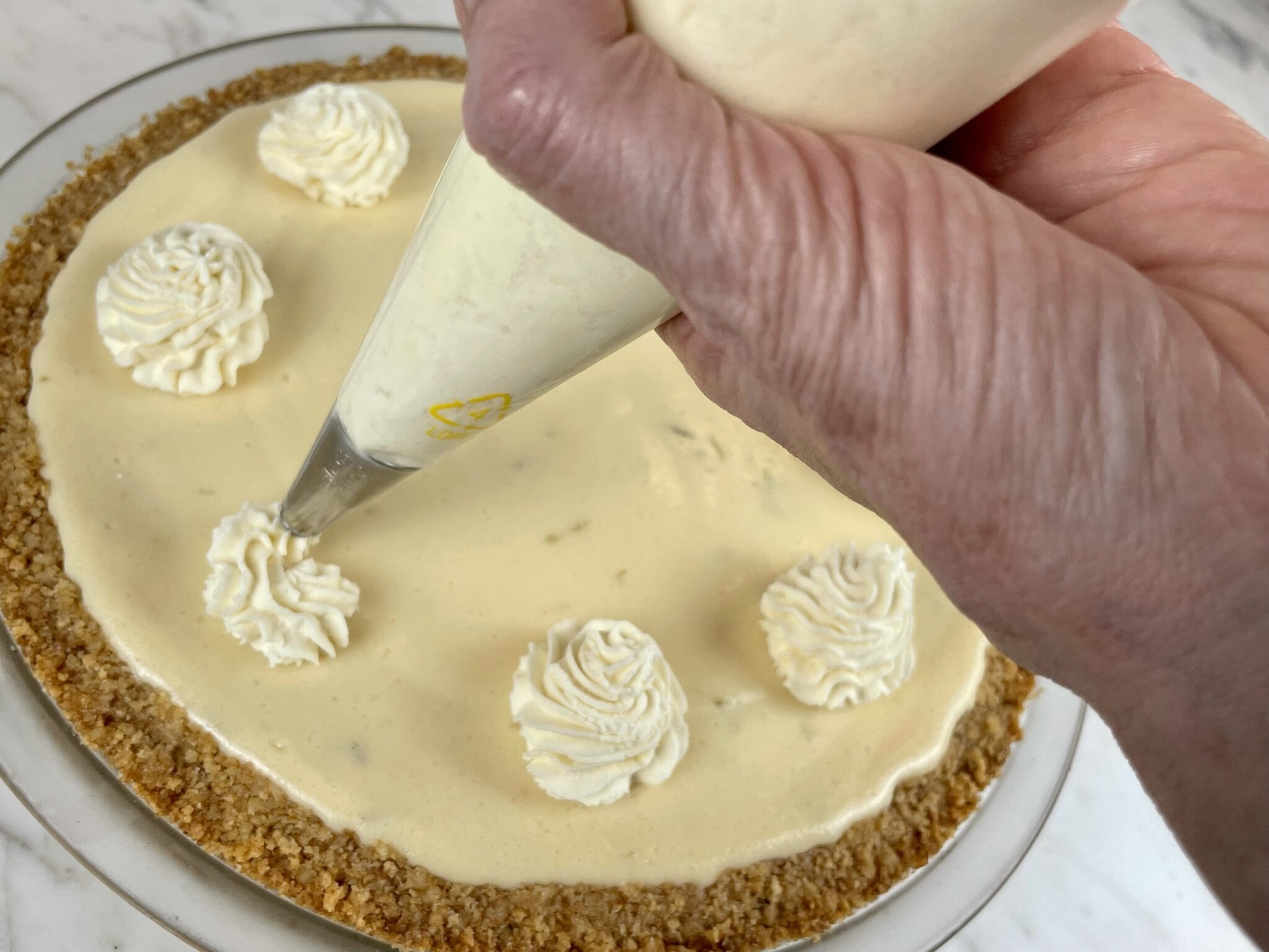 Pipe cream onto pie.